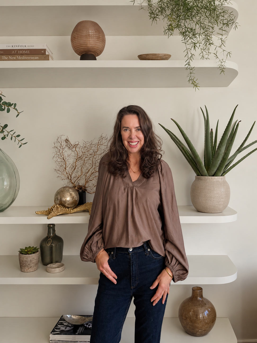 Sandra van Aalst founder of Interior Style Host standing in front of white curved shelves
