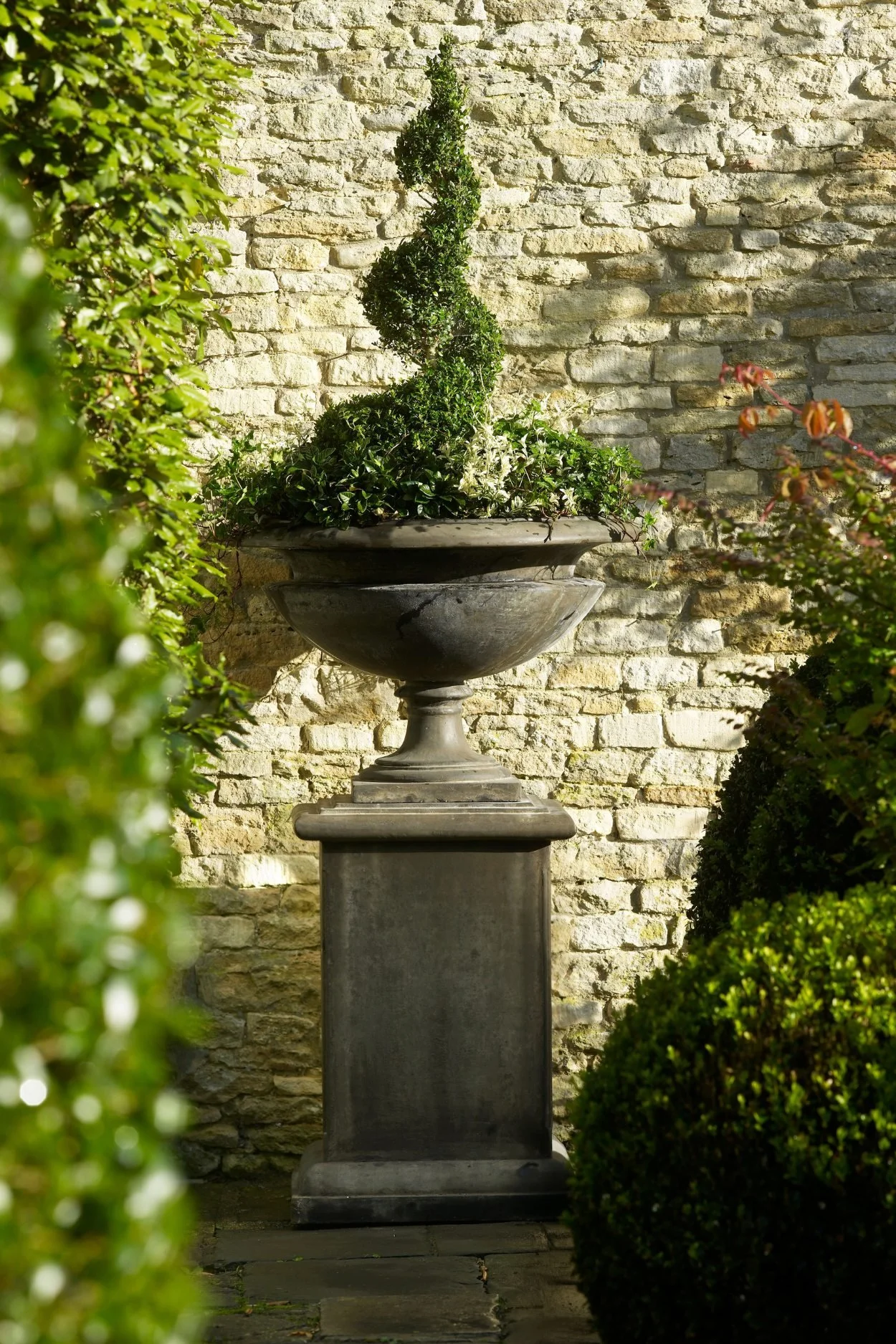 Cast-iron garden urn on a decorative pedestal