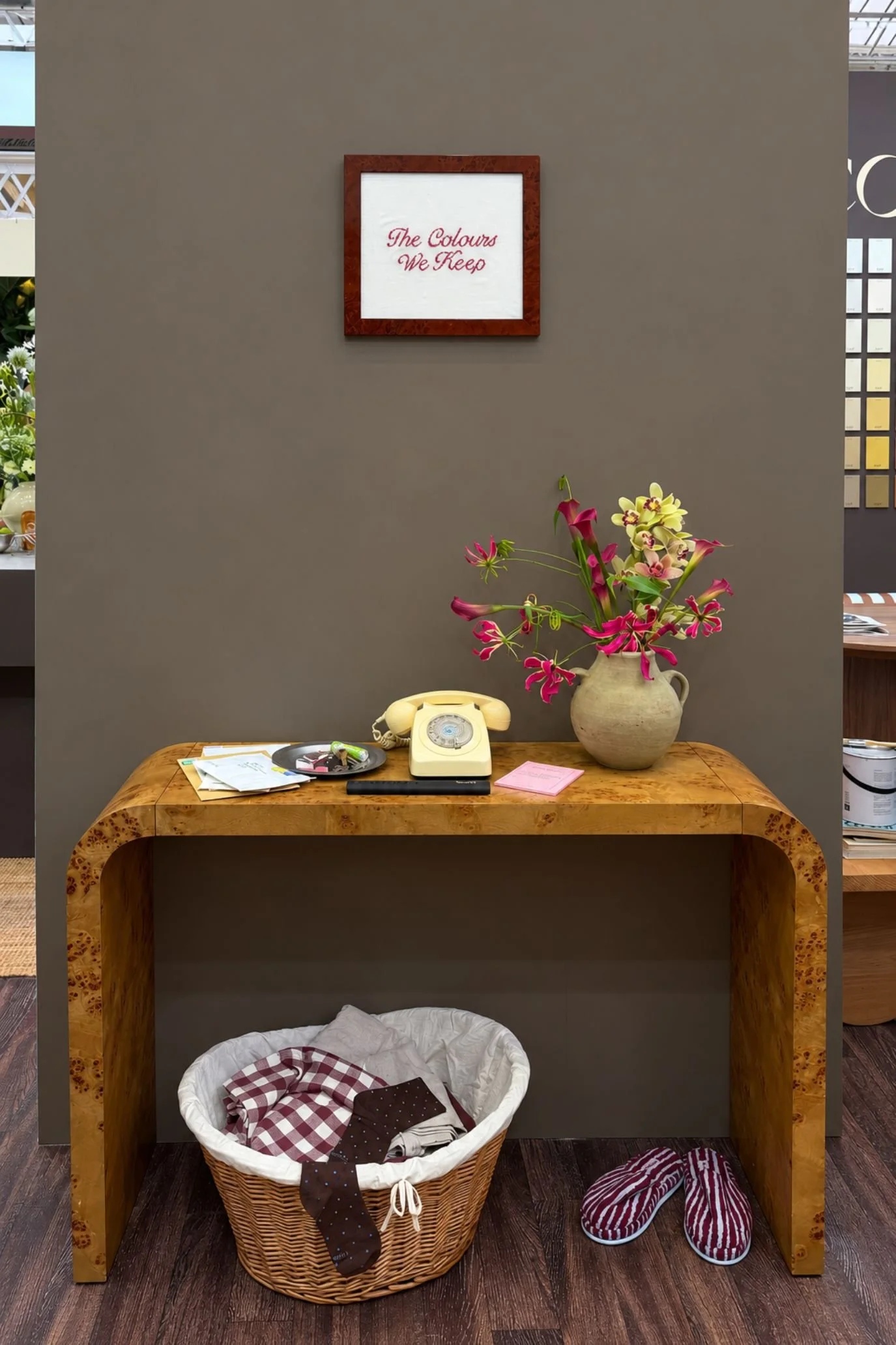 Wooden console styled with a vintage telephone and flowers against a warm, earthy painted wall.
