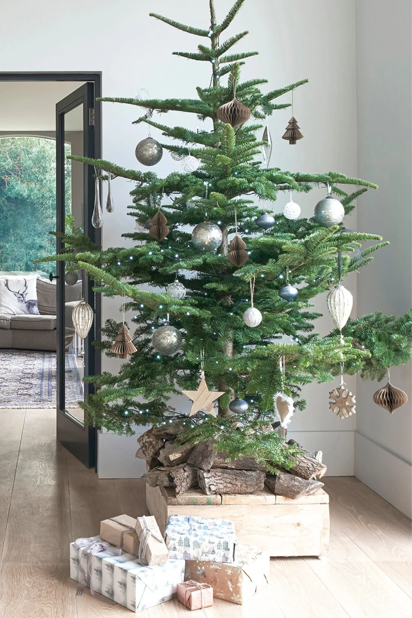 Natural Christmas tree decorated with metal and glass baubles, brown paper ornaments and different fairies