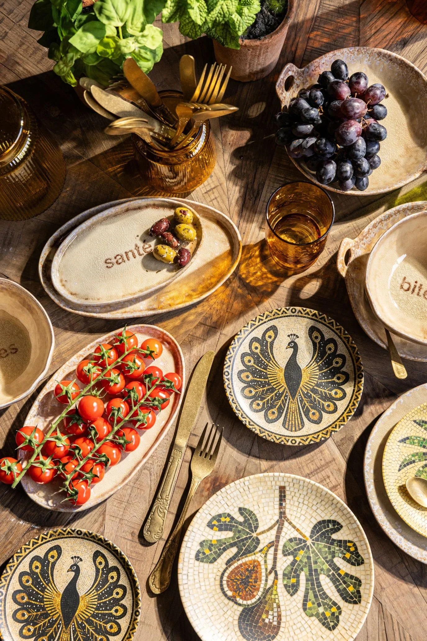 a table with dishes with words inscribed as well as mosaic designs with peacock illustrations