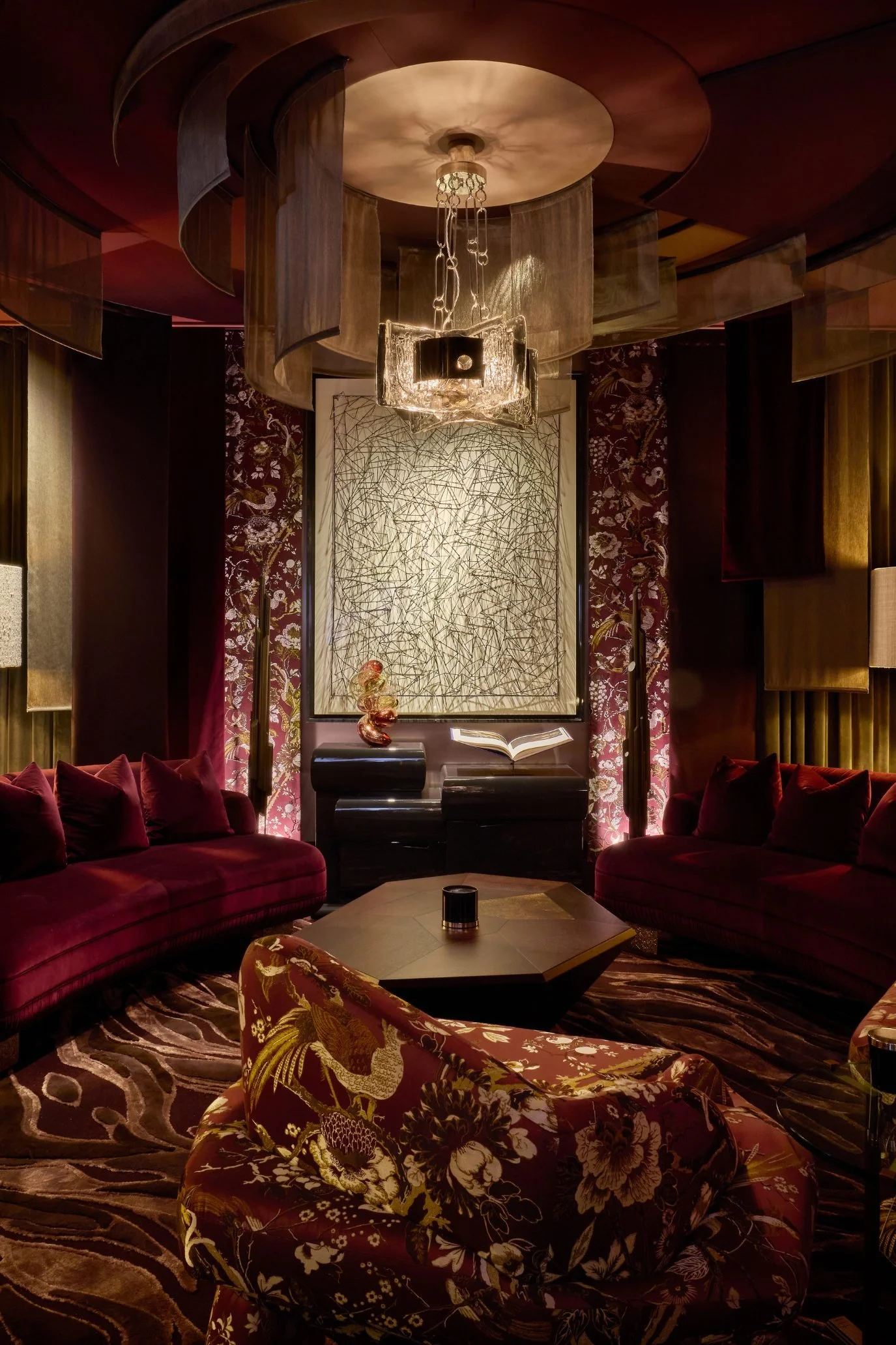 The Parlour at WOW!house by Martin Kemp Design featuring deep red tones, metallic accents and atmospheric lighting.