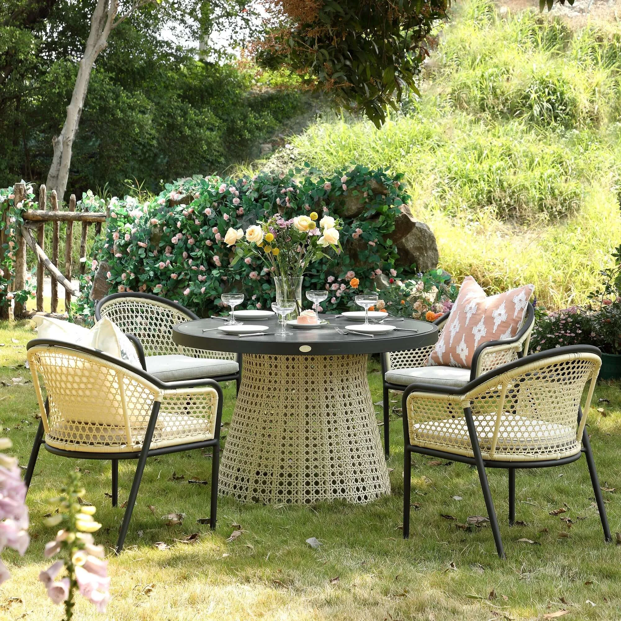 stylish outdoor table in a contemporary rattan style with a grey top and four chairs