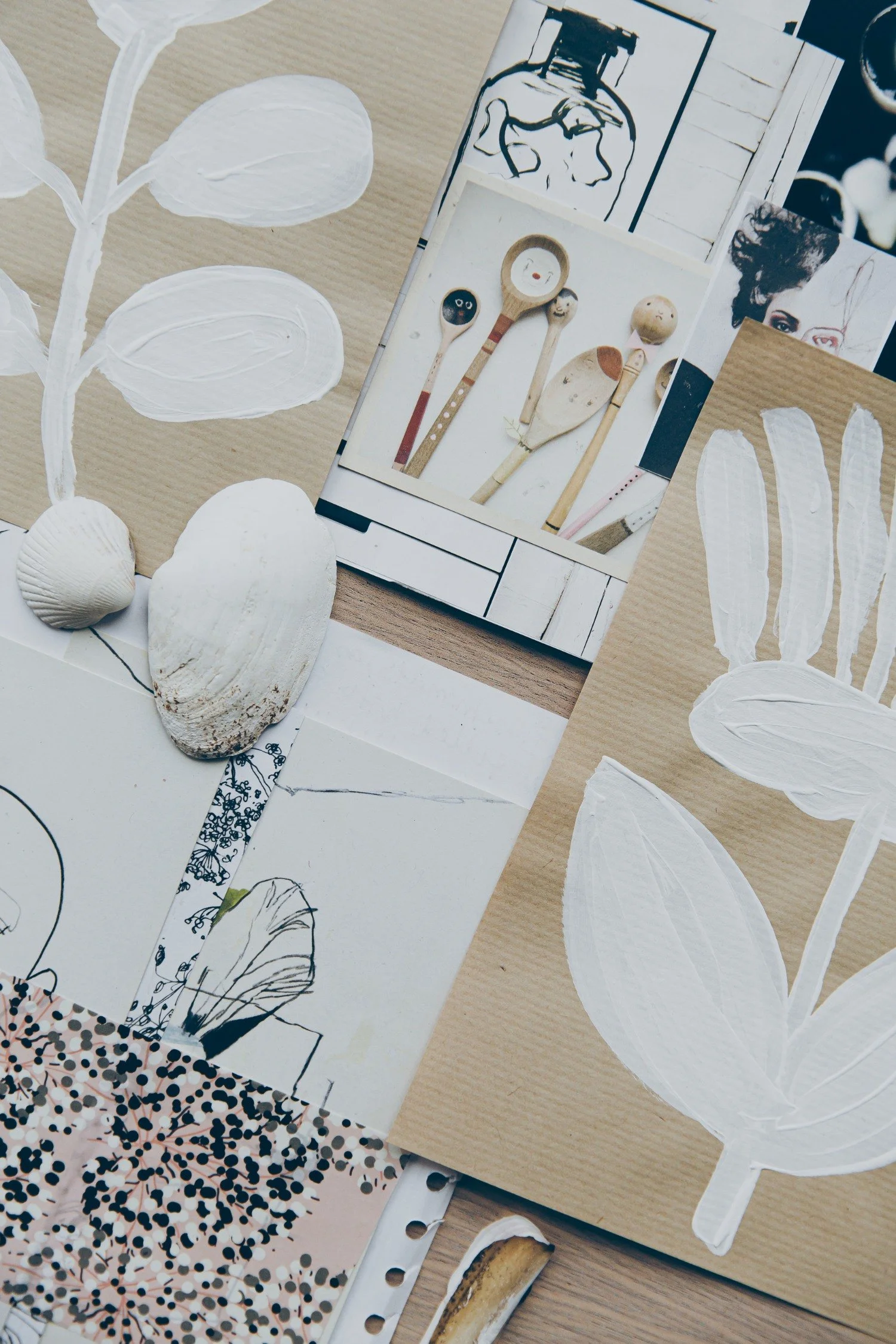 A collage with artistic images and paintings of white leaves on brown paper