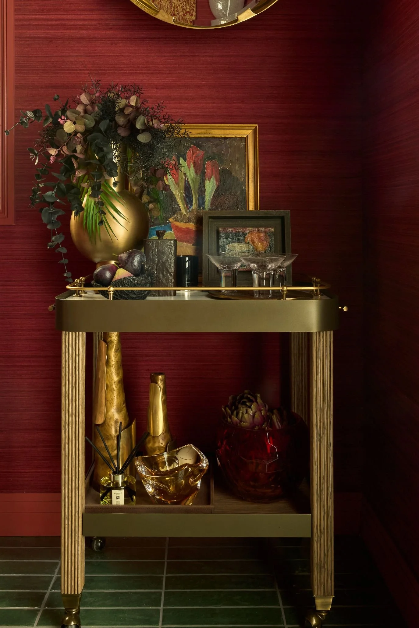 metallic bar cart with framed artwork, flowers and glass ornaments