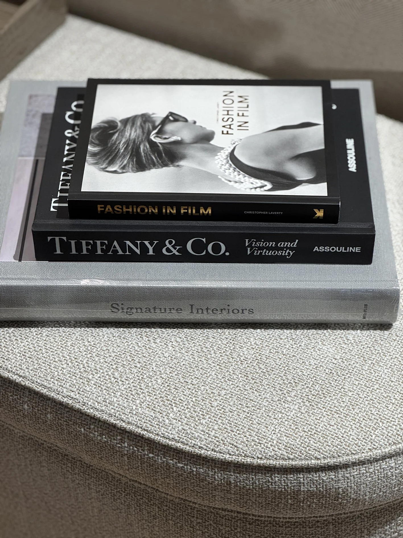 stylish books about interiors, Tiffany & co and Fashion in film placed in a pile on a wool ottoman.