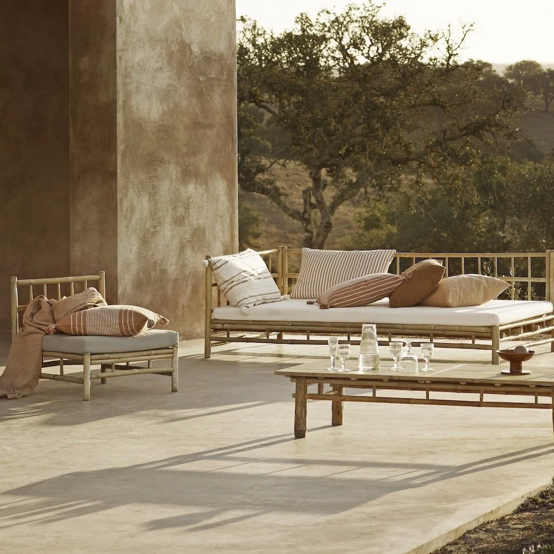 Terrace seating with striped outdoor cushions in soft terracotta and neutral tones