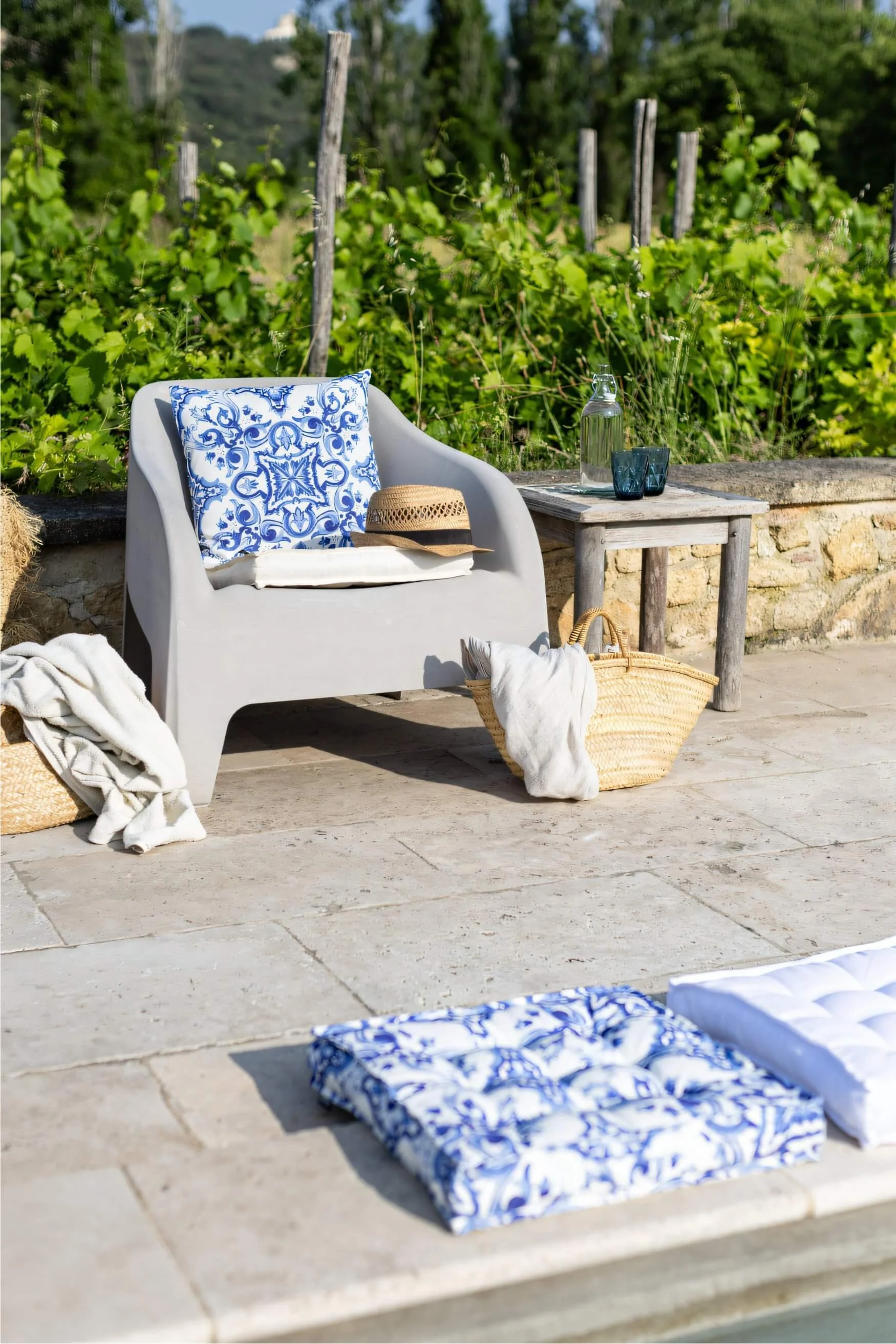 Outdoor chair with a blue and white patterned cushion on a sunny Mediterranean-style patio