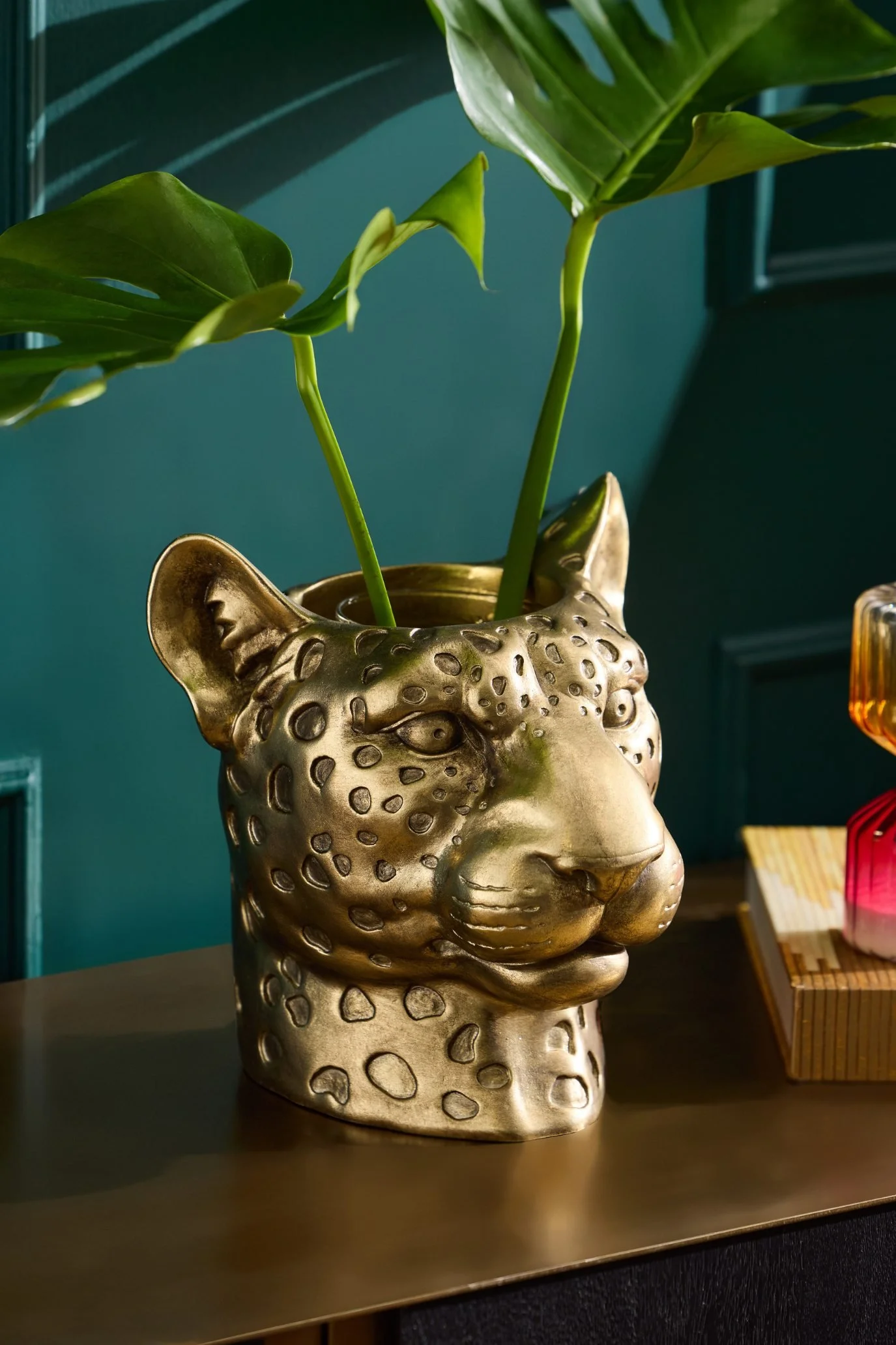 Gold-toned leopard head vase with a detailed sculptural metallic finish.