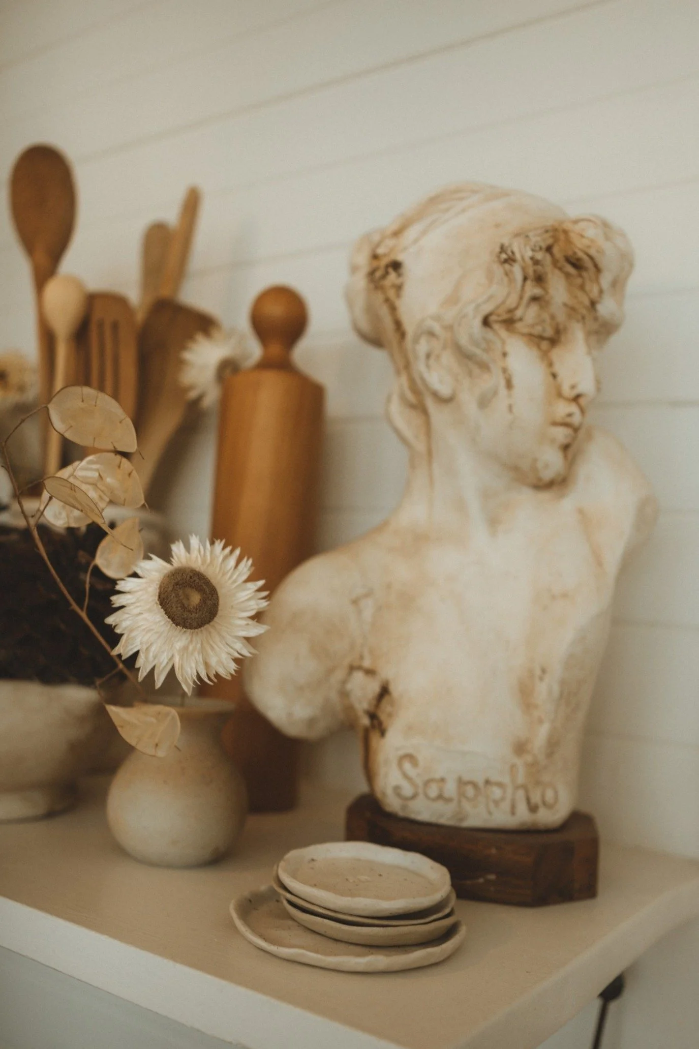 Vintage-inspired kitchen shelving at Captain’s Rest styled with stoneware, antique decor, dried flowers and collected objects.