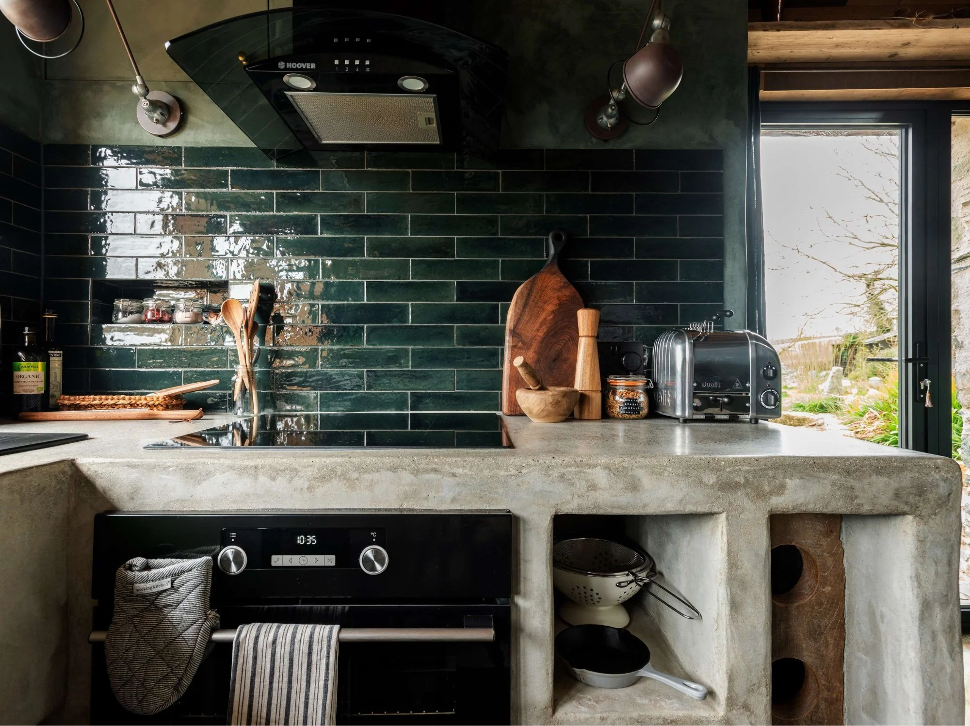 Devon barn conversion with green glossed tiles and a grey concrete kitchen worktop