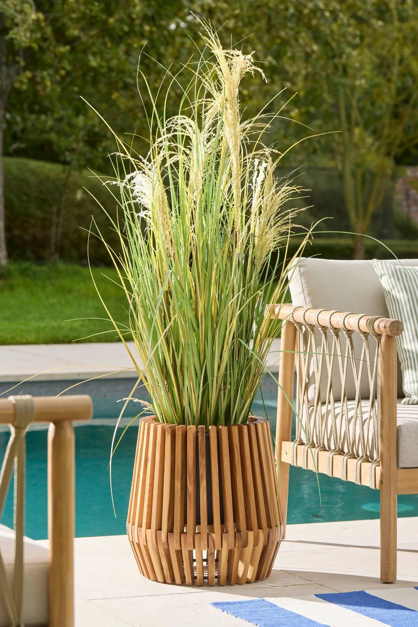 Slatted wooden outdoor planter by Cox & Cox on a terrace