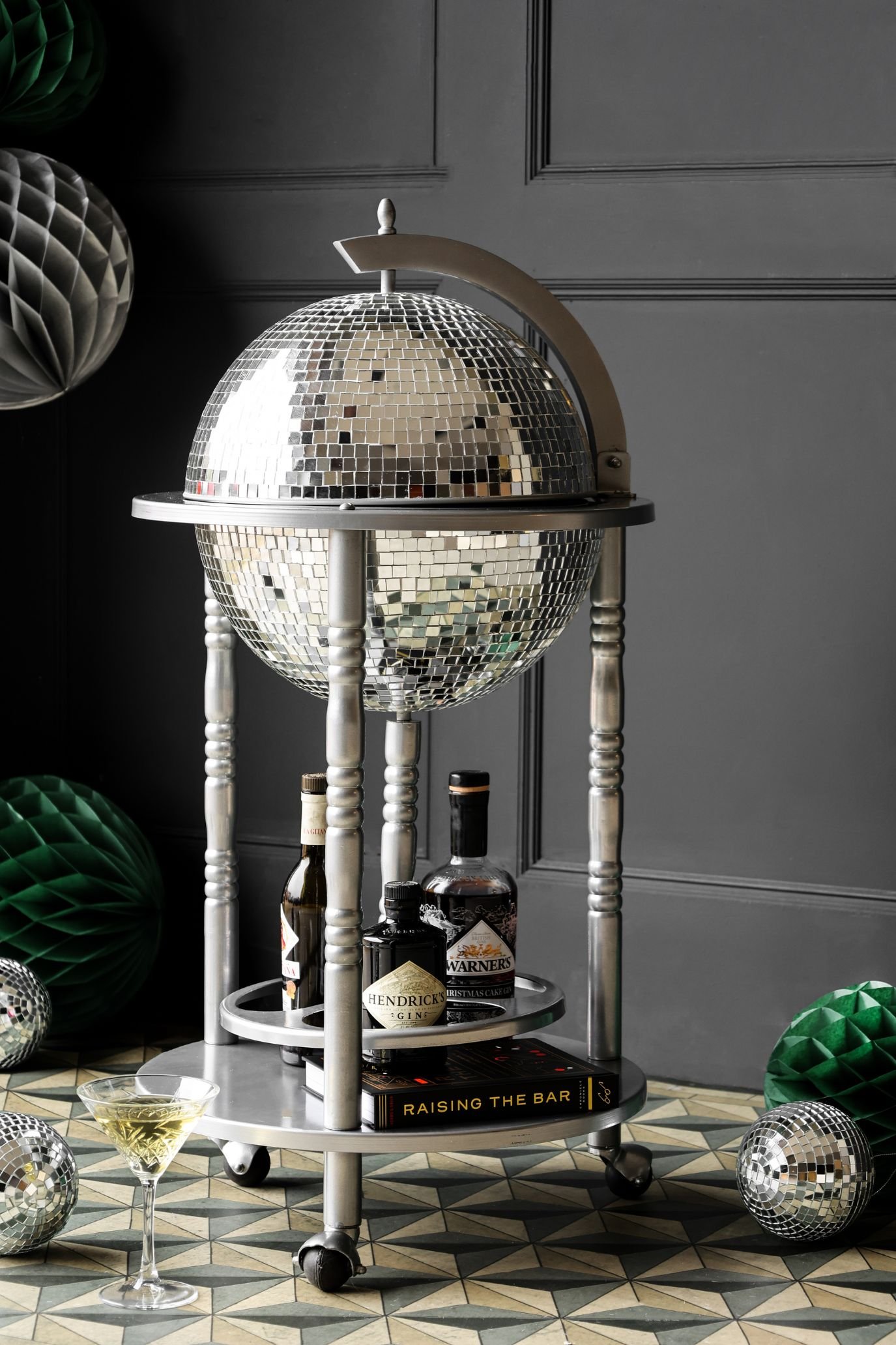silver disco ball drinks trolley infront of grey paneling