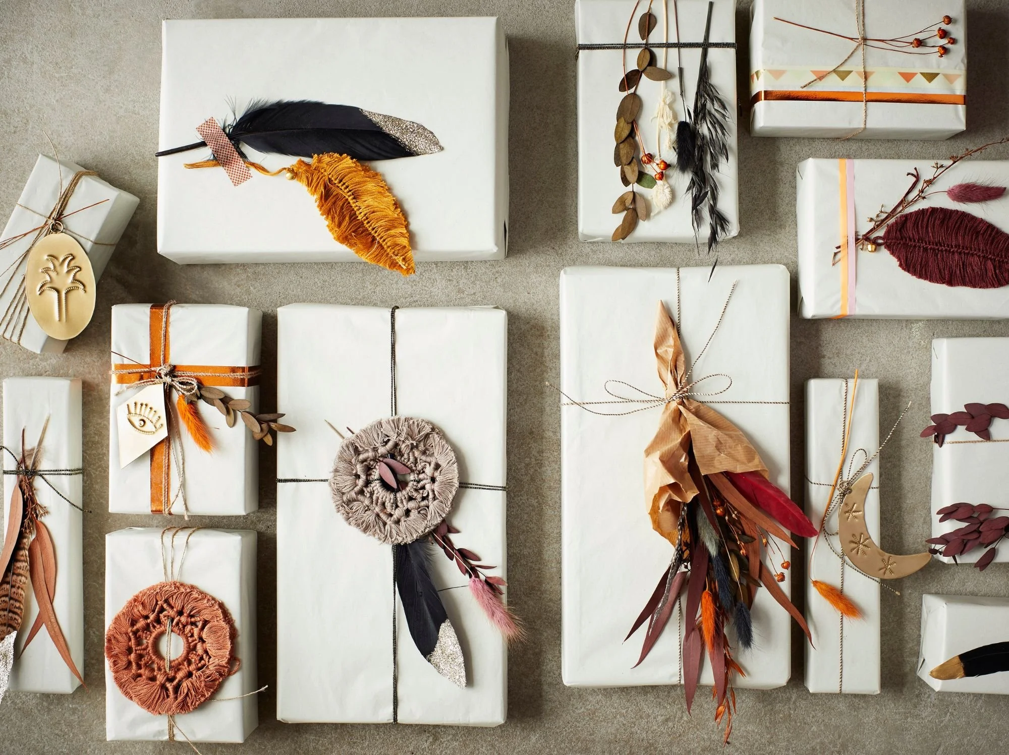 white gifts finished with a sprig of dried grass or a leaf