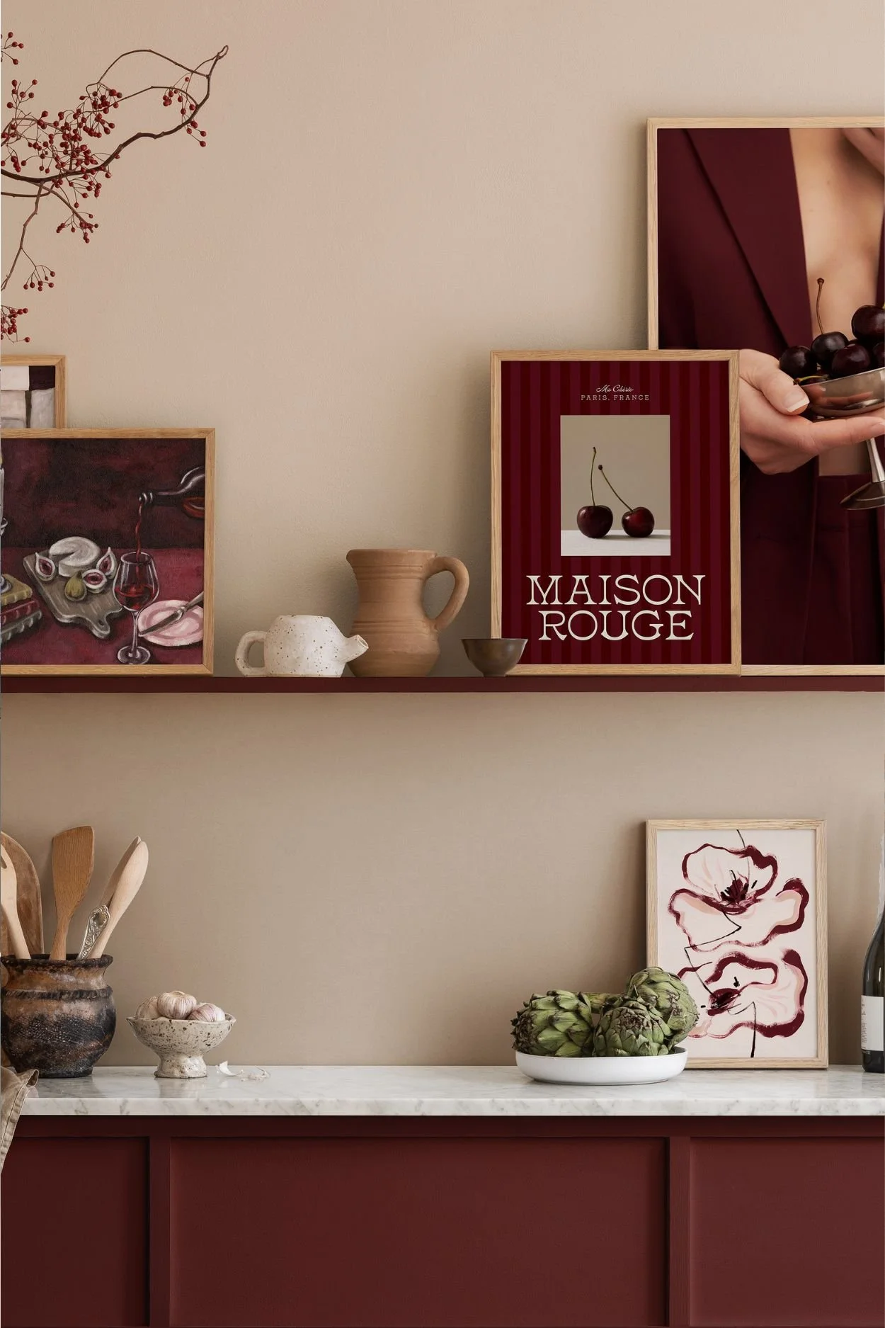 A Burgundy-toned kitchen with a shelf with frames in the same tone