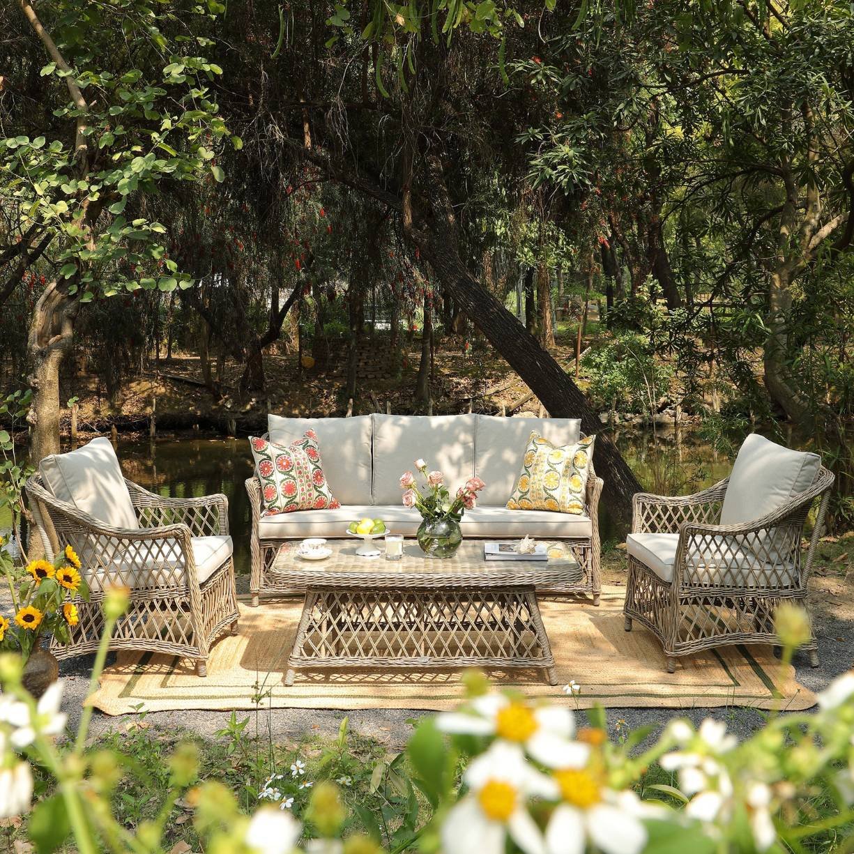 A lattice style outdoor sofa set on a jute rug situated in a garden