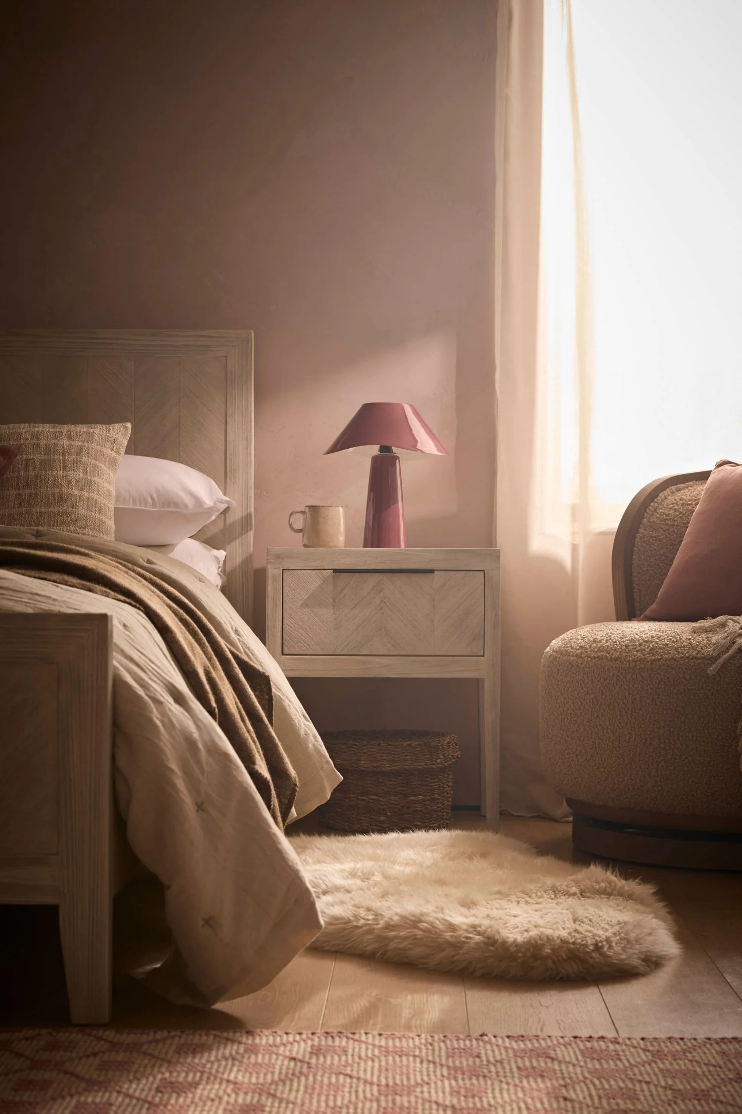 Pale limewashed wood nightstand with chevron detailing in a warm neutral bedroom