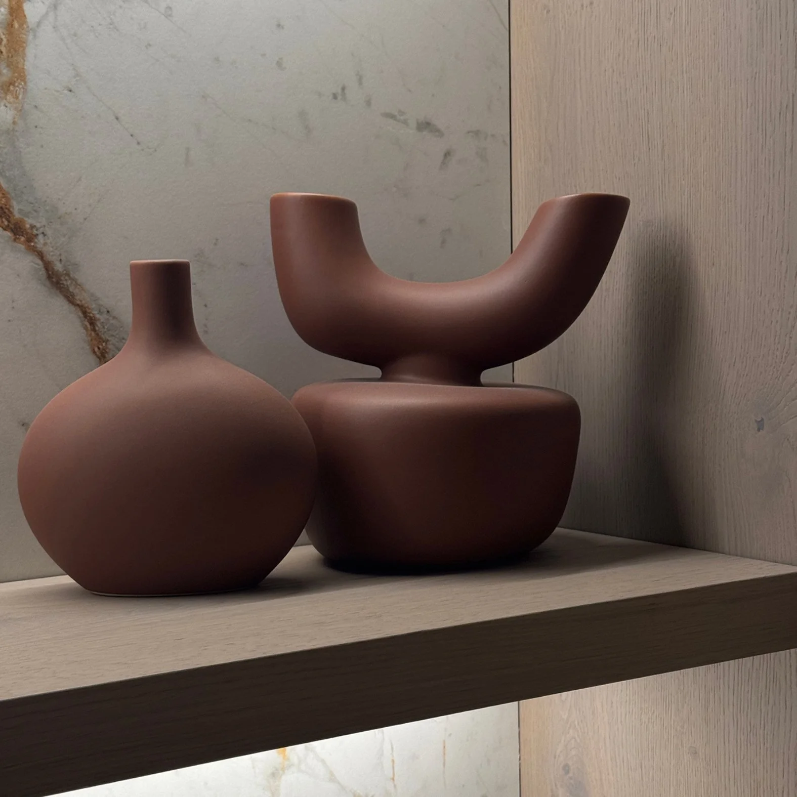 two stylish vessels in  earthy tones made of stone.