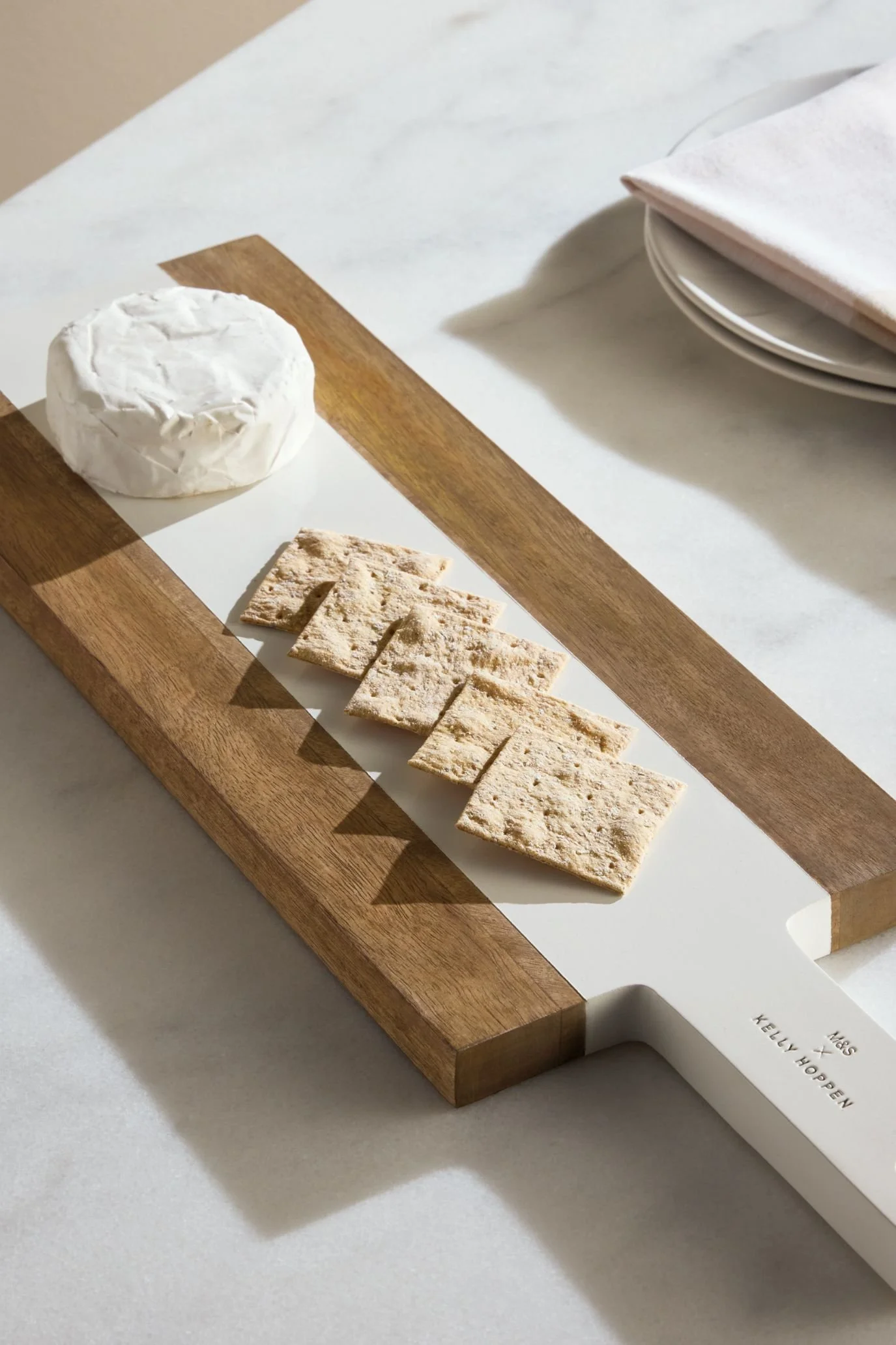 Kelly Hoppen x M&S wooden serving board with a raised central section, styled with cheese and crackers.