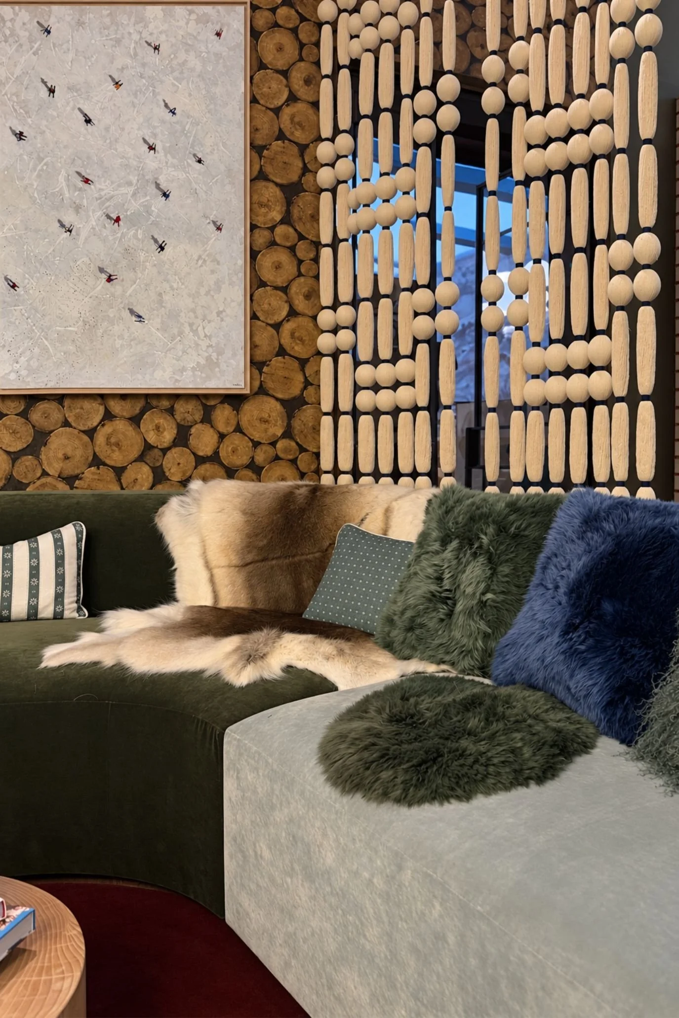 Cosy seating with textured cushions beside a decorative timber room divider in Claudia Dorsch’s chalet-inspired lounge.