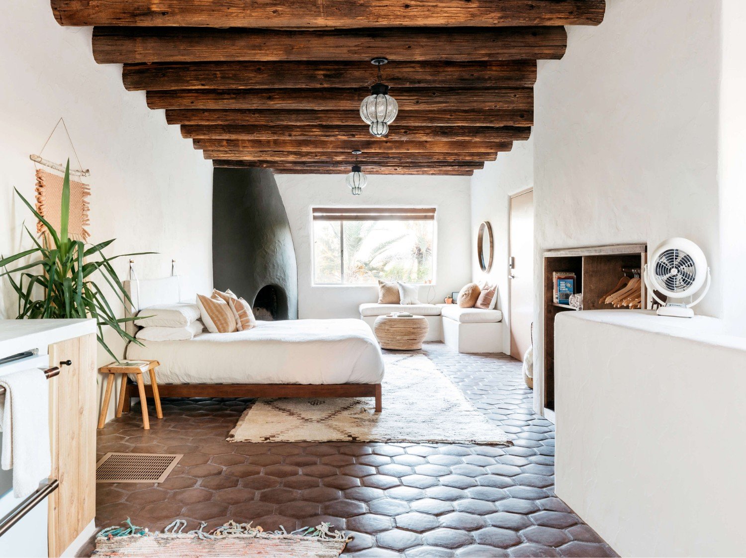 Beautifully styled vacation rental bedroom with rattan decor and layered textiles