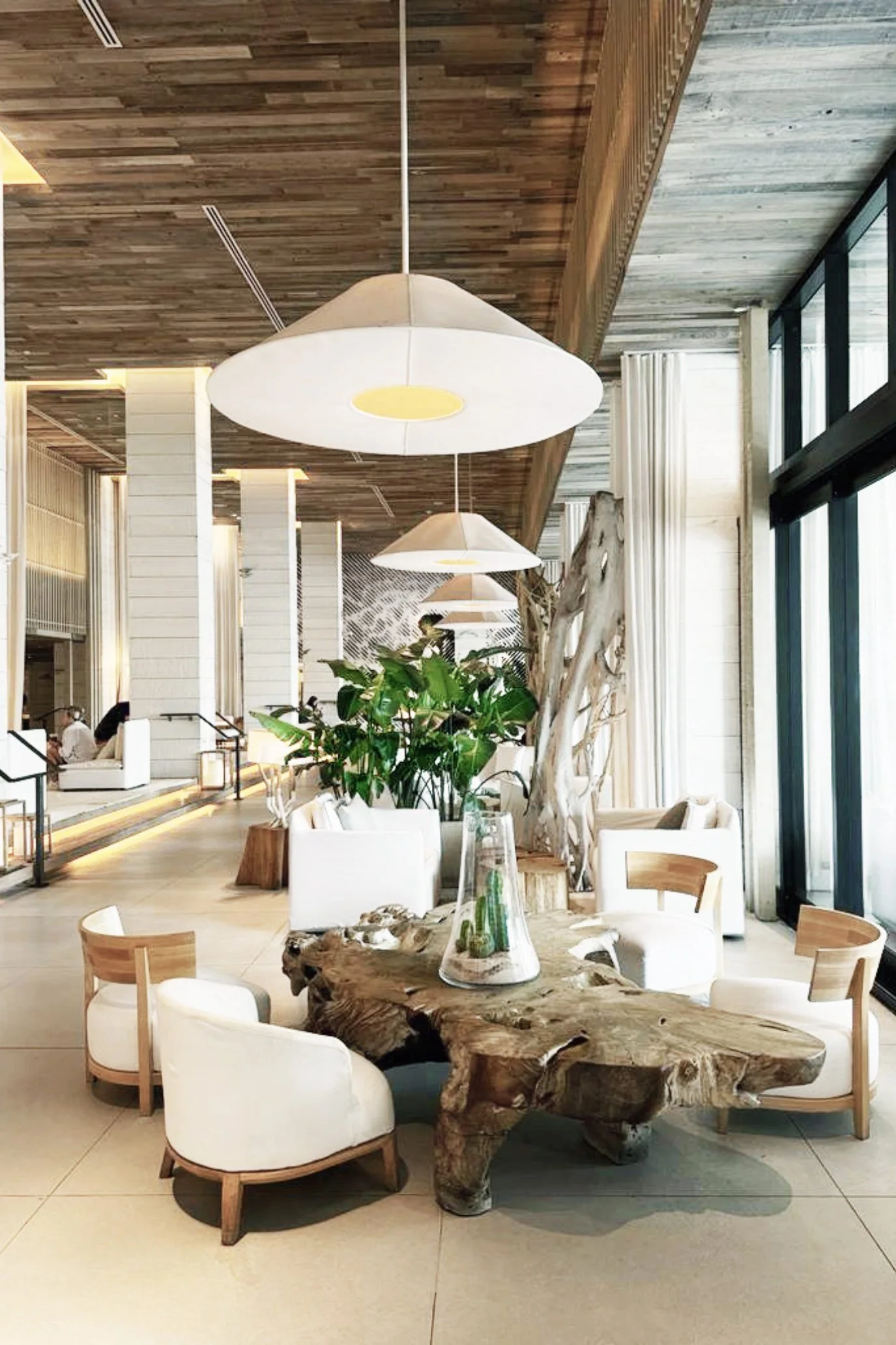 from Hotels with vast off white linen pendant lights, natural wood coffee tables, and on trend curved chairs all in the lobby of the 1 Hotel Miami South Beach