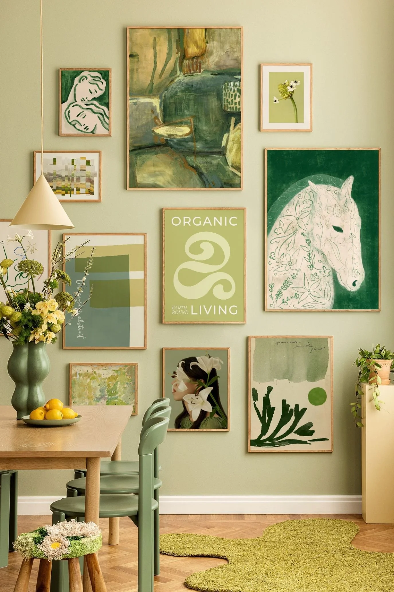 Gallery wall of green-toned botanical, landscape and horse prints above a dining area with green chairs.