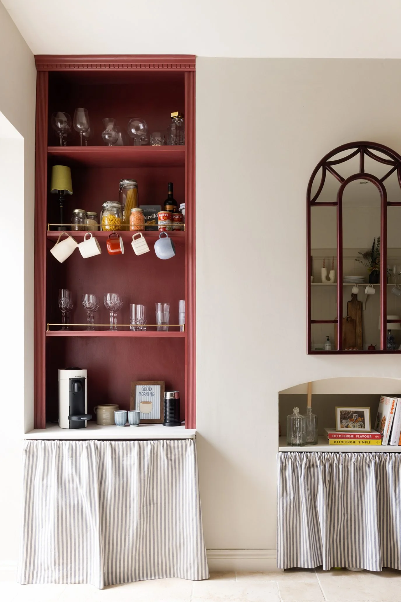 Rehome kitchen with deep red painted alcove shelving creating a colourful feature on an otherwise plain wall.