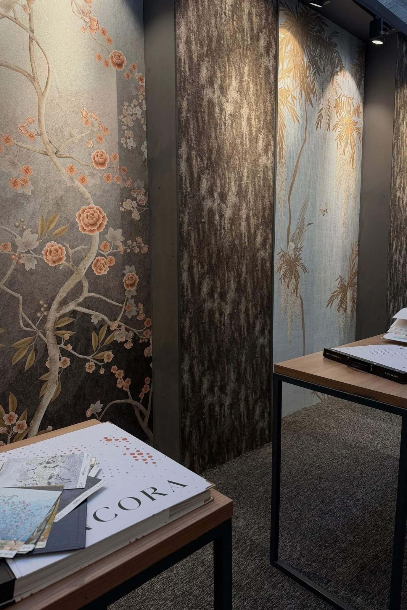 wall coverings with floral and leaf designs on panels on a stand at Decorex