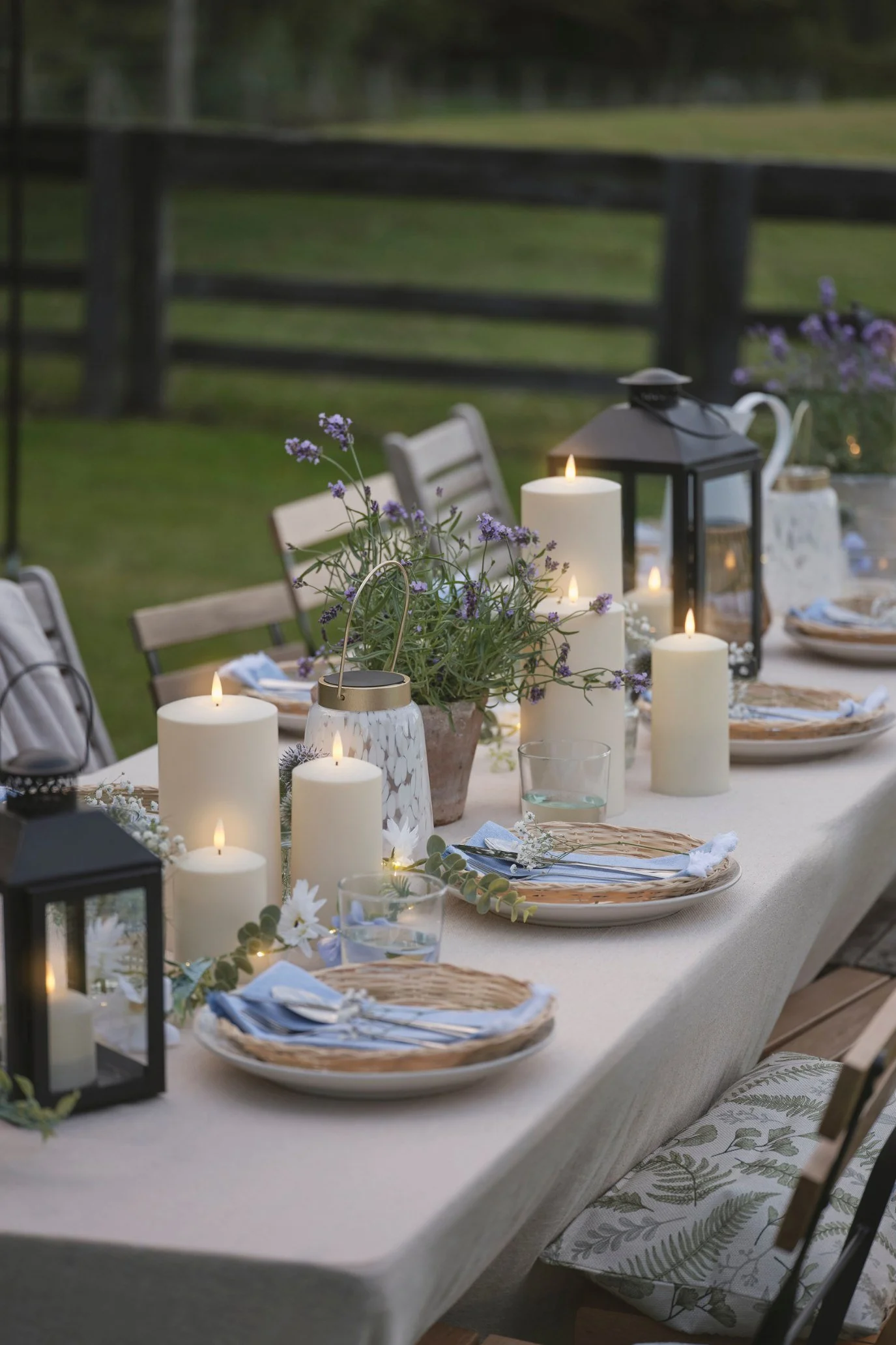 Outdoor lighting ideas with LED candles and lanterns creating a warm and inviting alfresco dining tablescape.