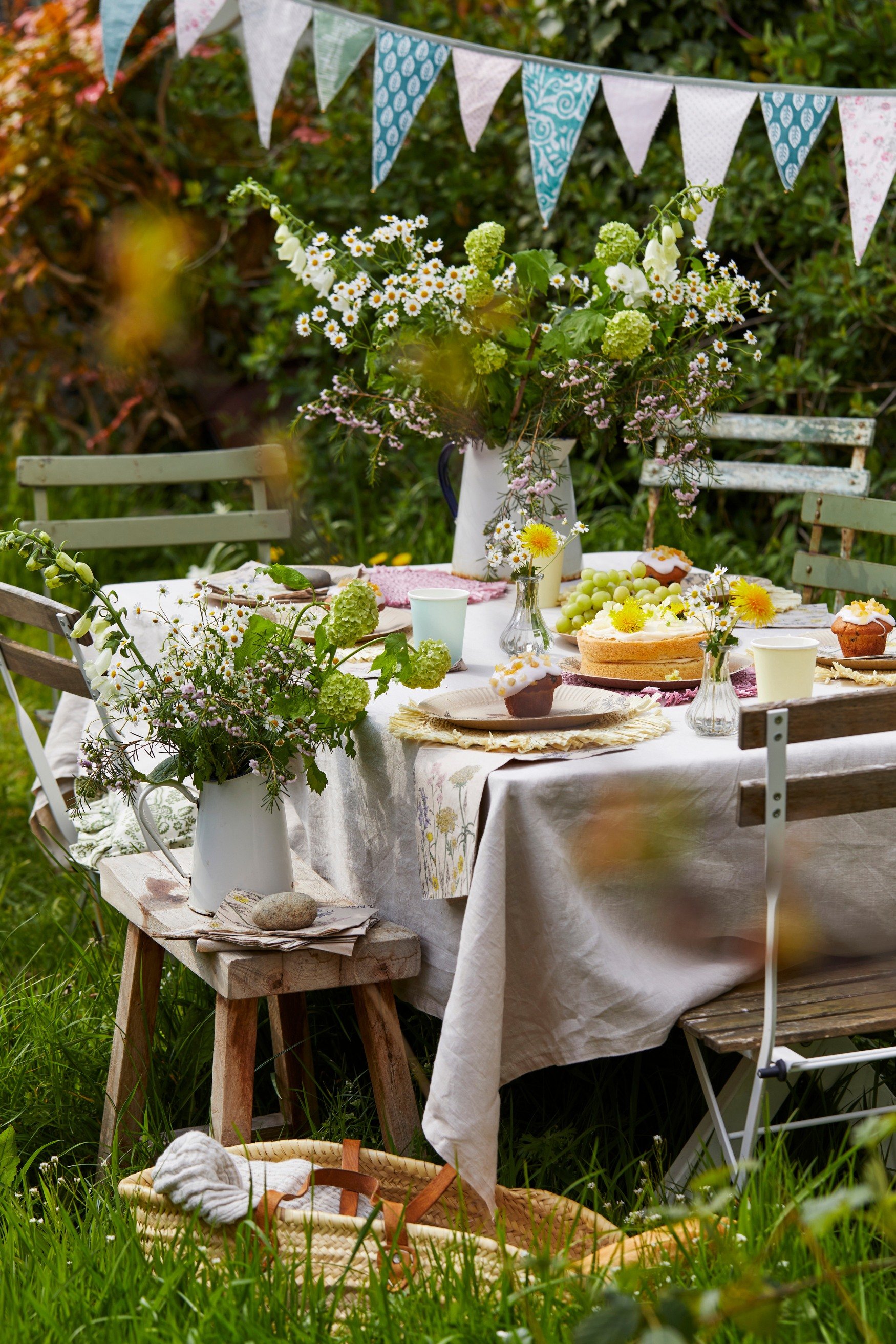 A meadow table set up with flowers and cakes for an Easter afternoon tea