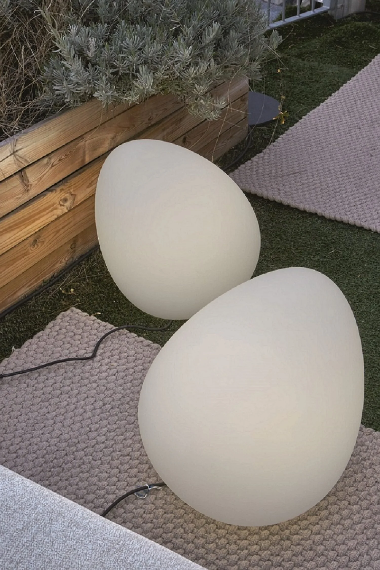 Decorative pebble-shaped outdoor lights adding sculptural interest to a modern garden.
