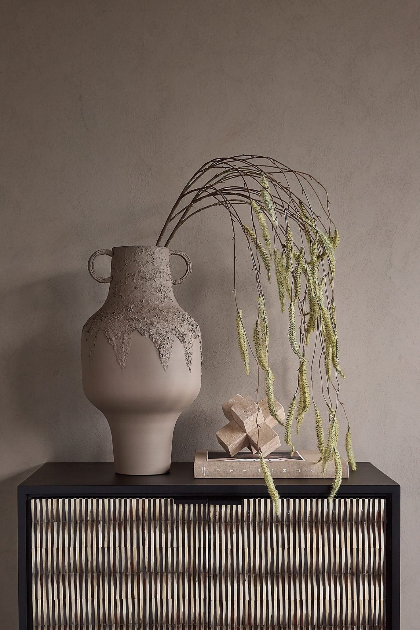 Sculptural ceramic modern vase with a textured finish styled with trailing branches.