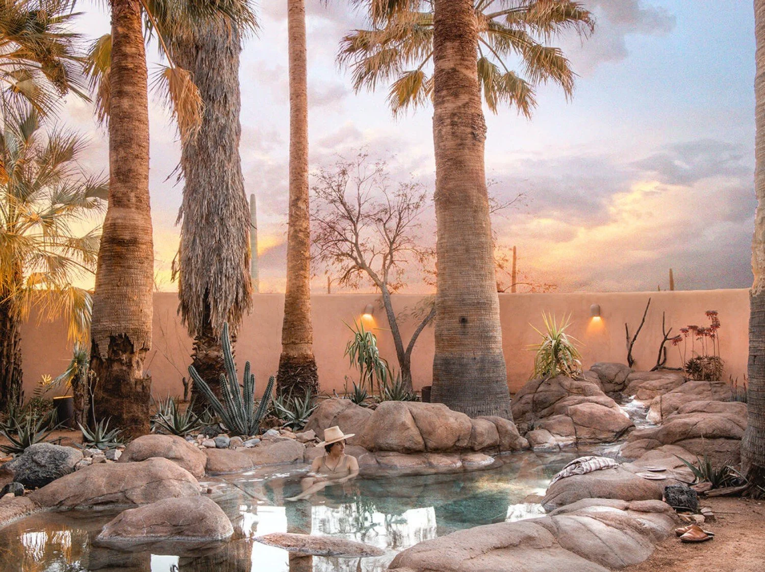 Natural hot springs at JTH Tucson surrounded by desert landscape and palm trees