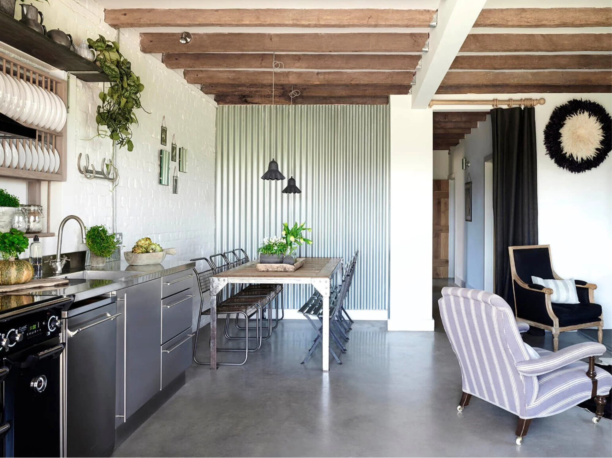 Rustic-industrial barn conversion with reclaimed materials, polished concrete floors, vintage furniture and wool wall art.