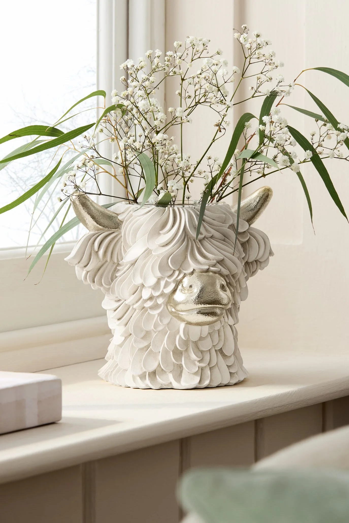 Sculptural Hamish head vase with gold detailing, glasses and delicate gypsophila flowers.