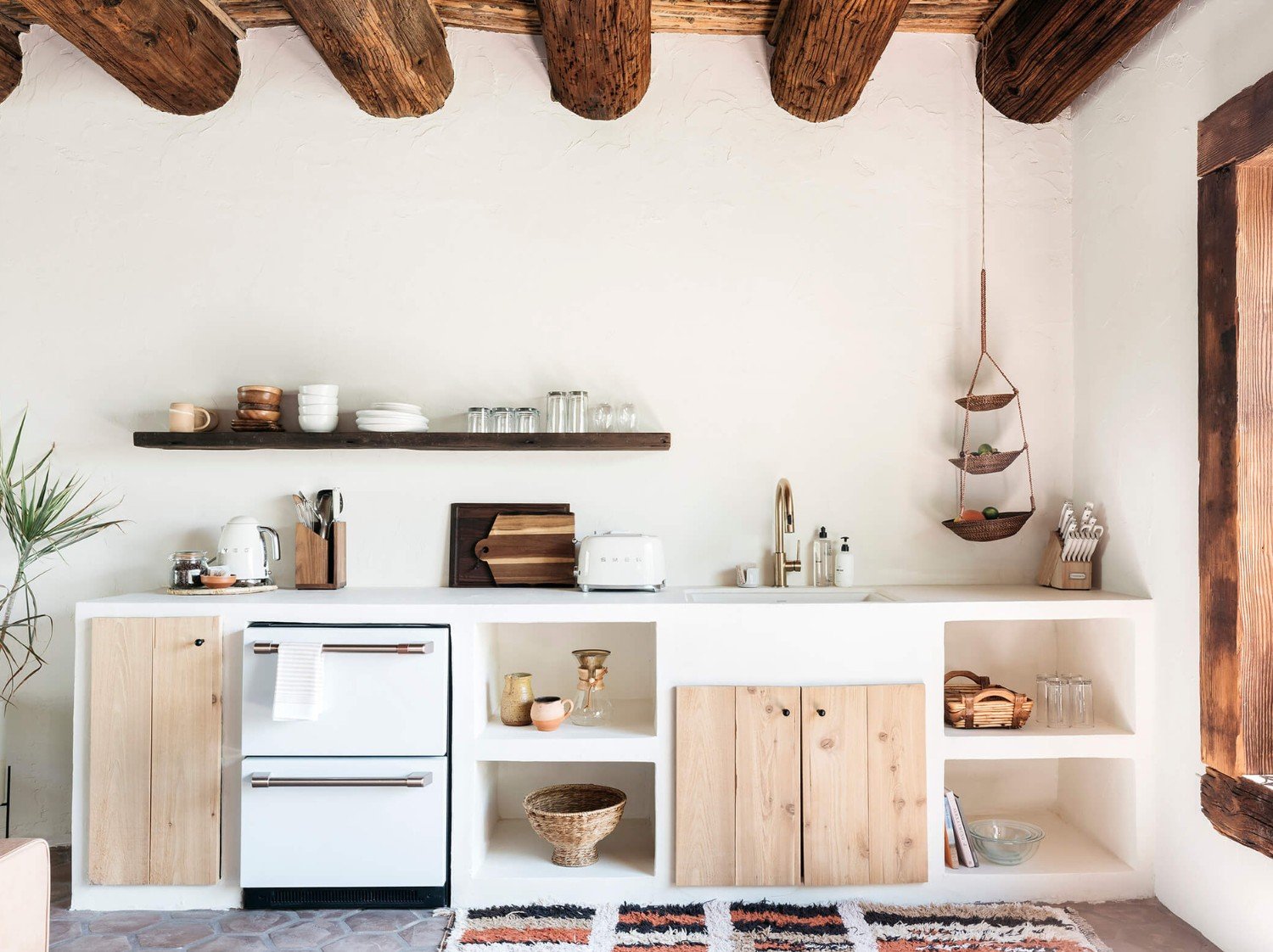Adobe-style kitchen at JTH Tucson with plaster cabinetry and warm wood accents