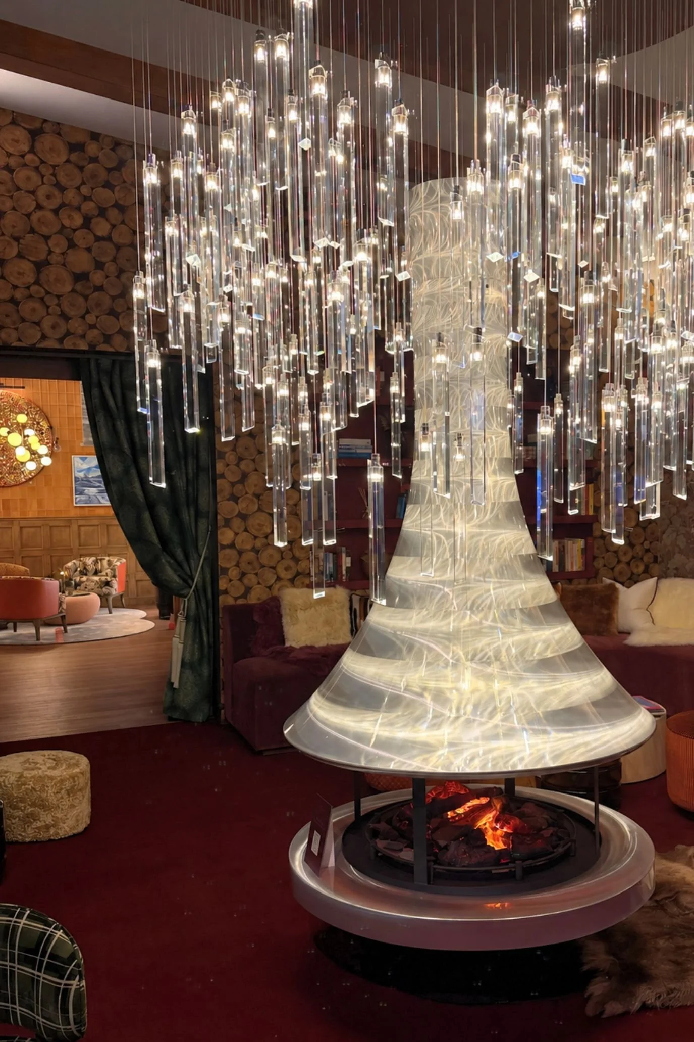 Suspended fireplace beneath a cascading crystal chandelier in Claudia Dorsch’s alpine-inspired VIP lounge at Decorex 2026.