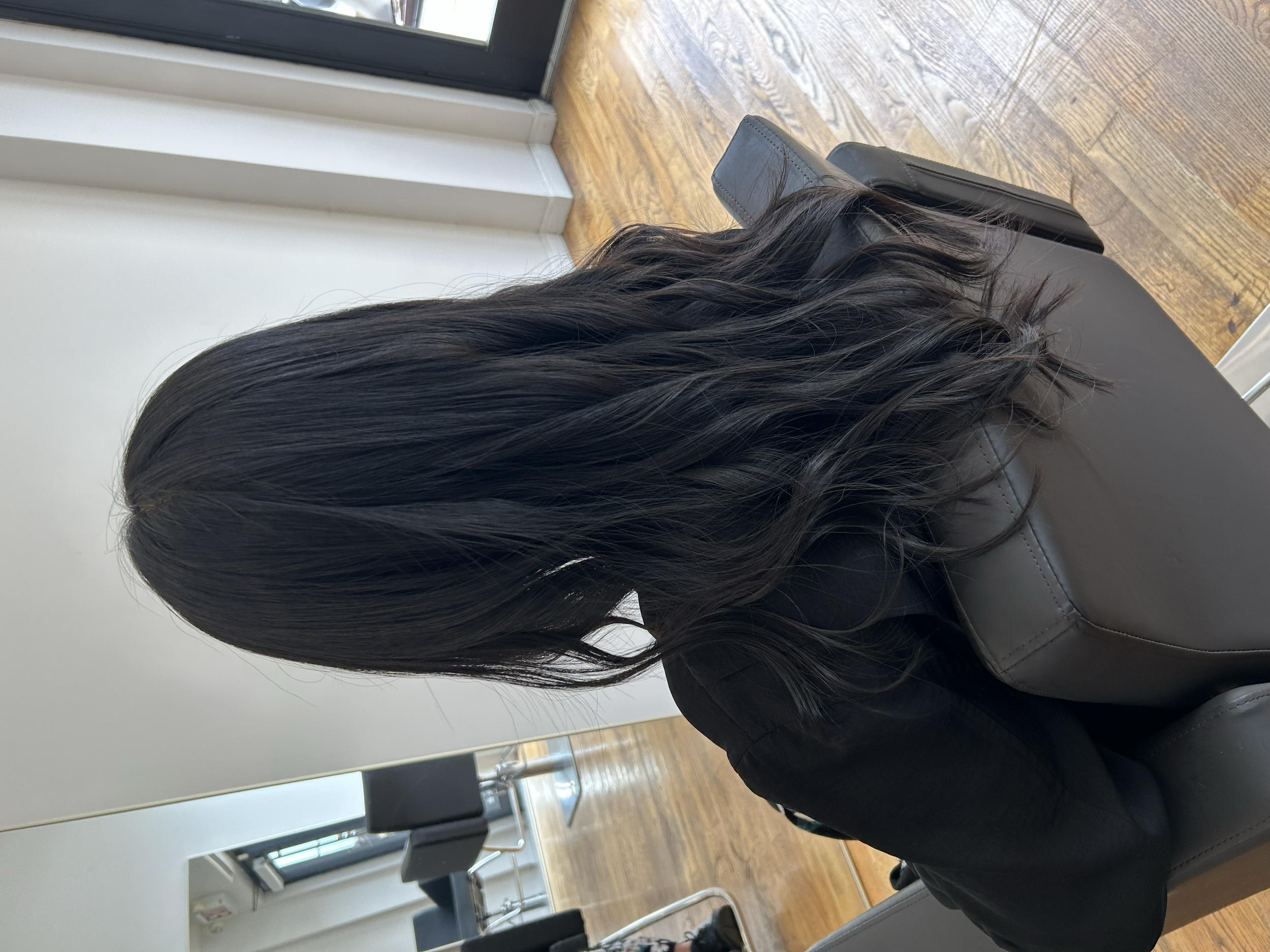 Long dark hair with soft waves and layered ends, styled at U&K Salon in Brooklyn.