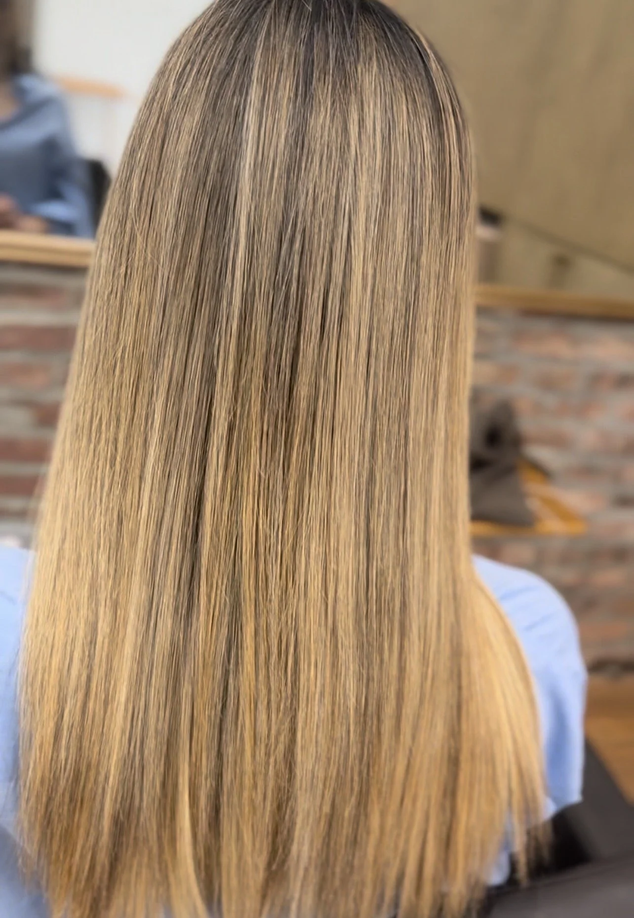Long, straight light brown hair with a sleek finish after keratin smoothing treatment at U&K Salon in Brooklyn.