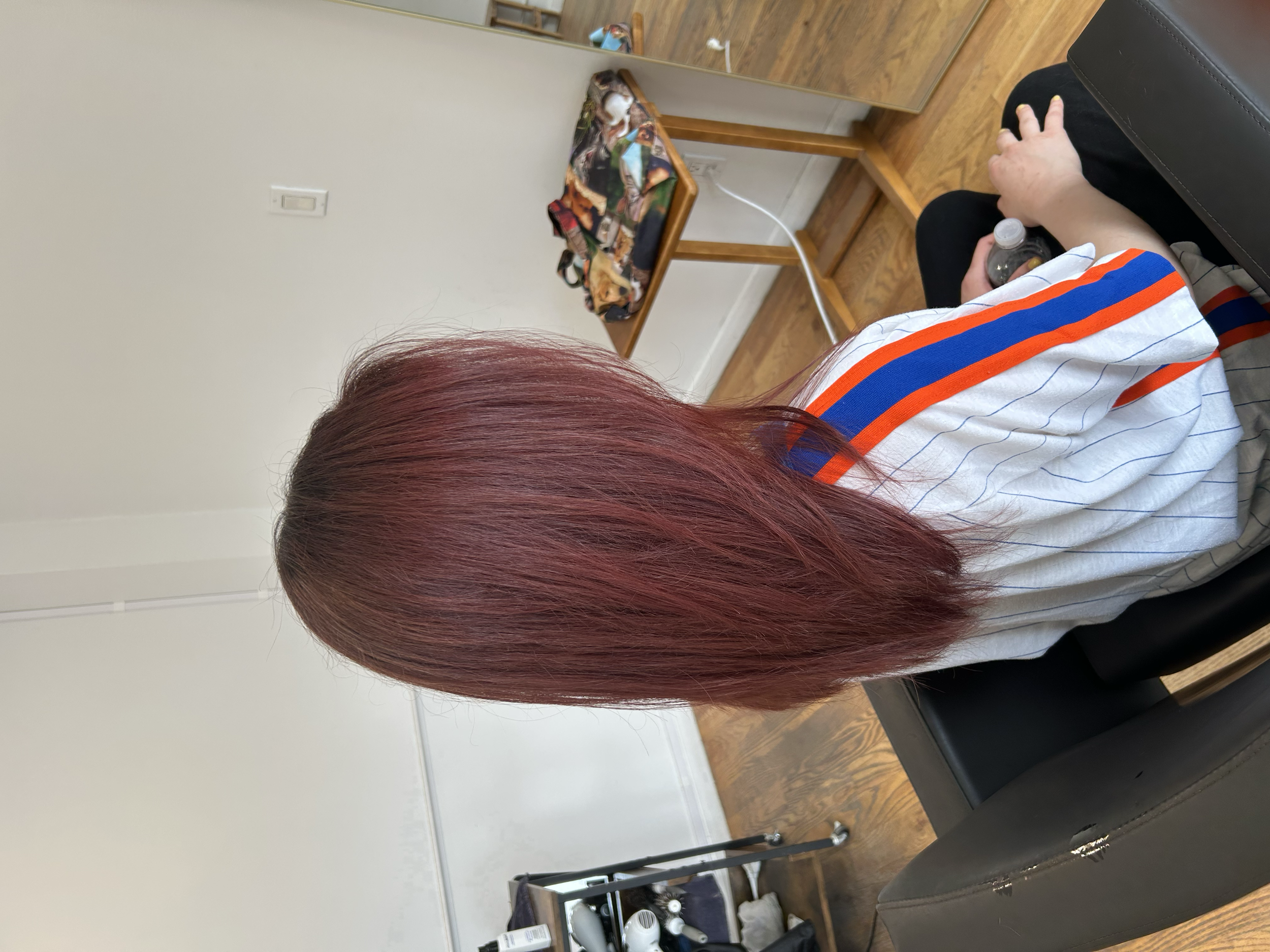 Long vibrant red hair with a smooth straight finish at U&K Salon in Brooklyn.
