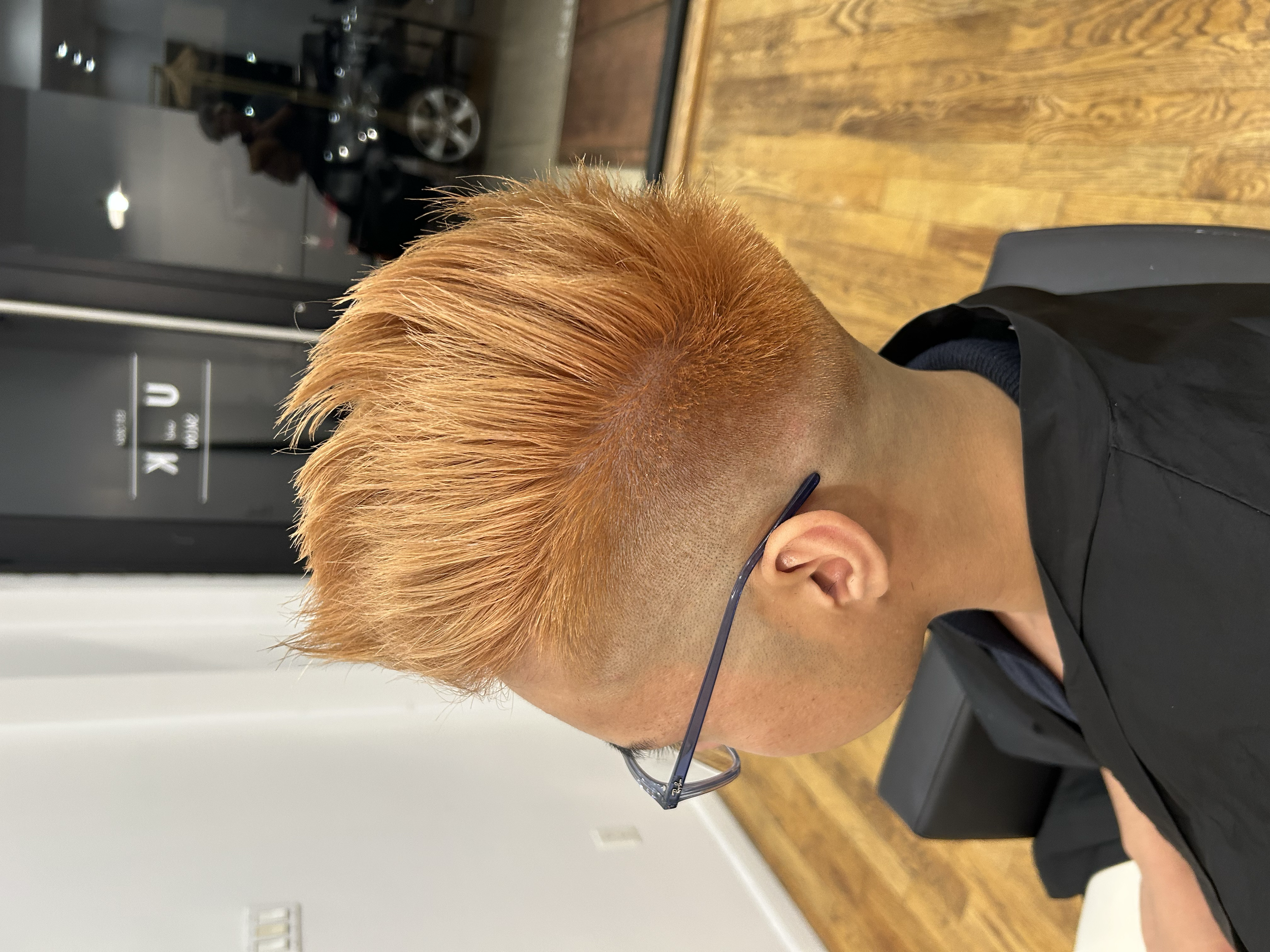 Bright orange spiky short haircut with faded sides, photographed at U&K Salon in Brooklyn.