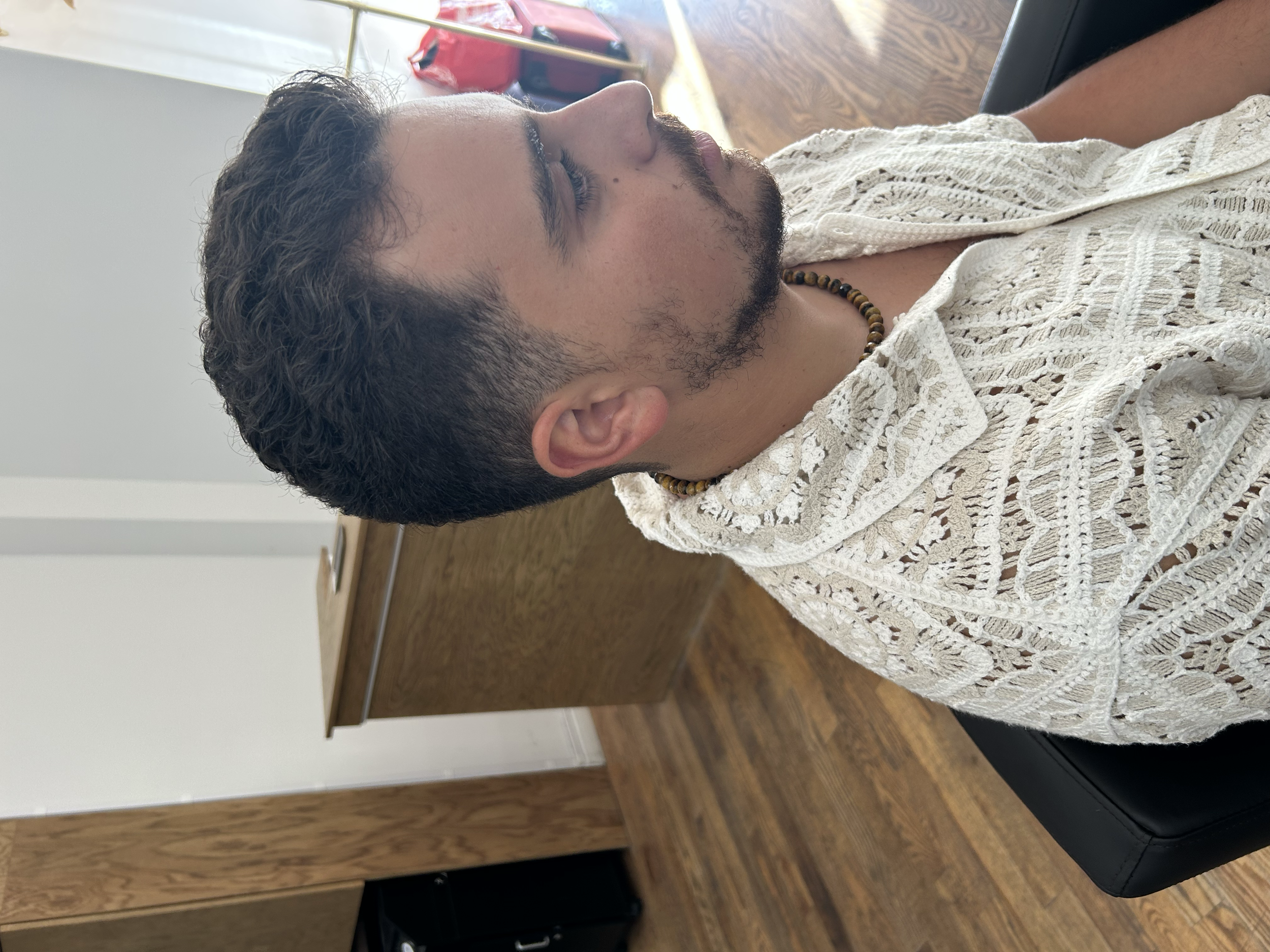 Men's short haircut with a natural tapered fade and textured top at U&K Salon in Brooklyn.