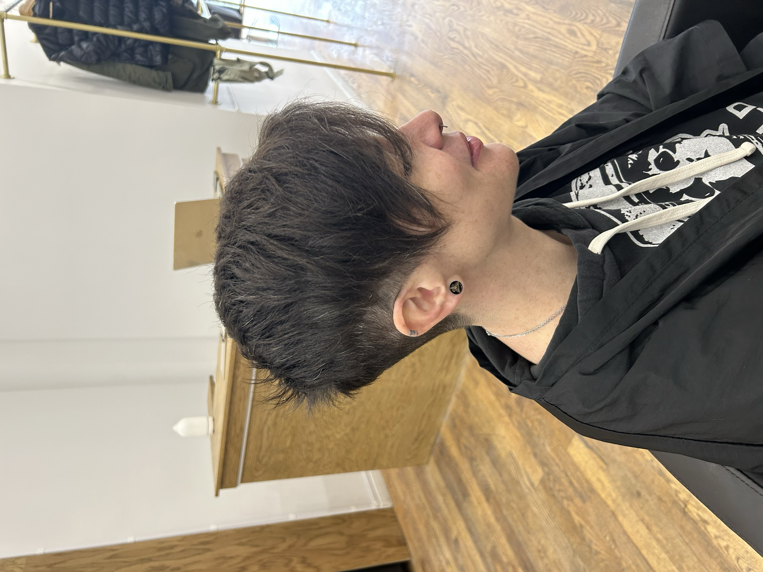 Asymmetrical short haircut with a long side fringe, textured layers, and closely tapered sides at U&K Salon in Brooklyn.