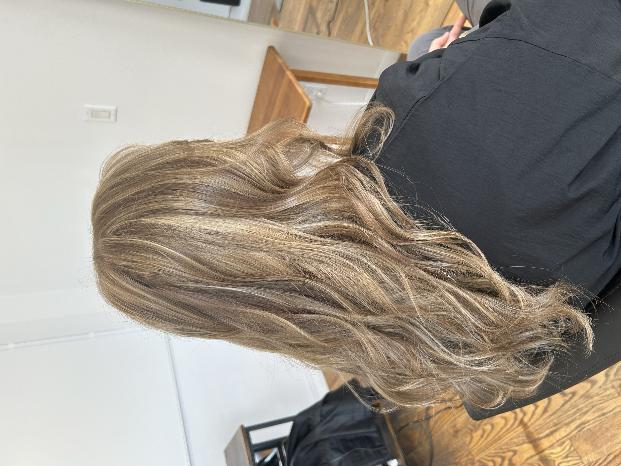 Long beige blonde hair with dimensional highlights and soft waves at U&K Salon in Brooklyn.