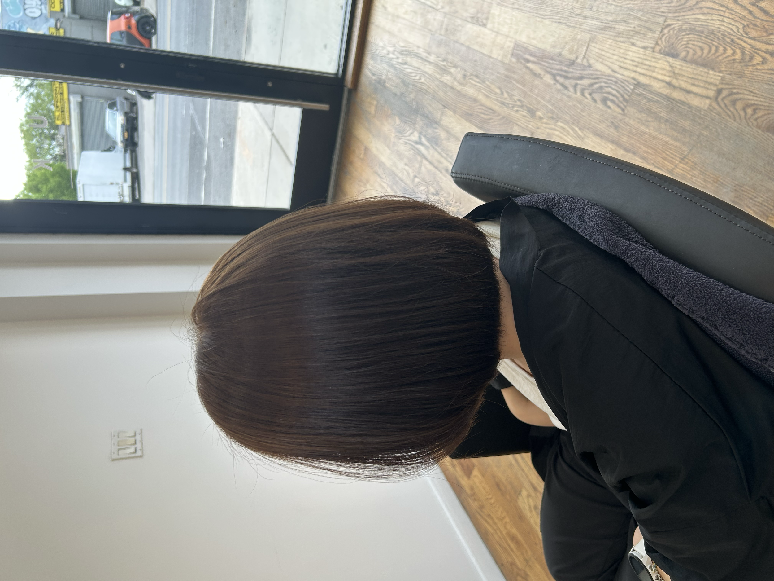 Rounded dark brown bob haircut with a smooth finish and clean neckline at U&K Salon in Brooklyn.
