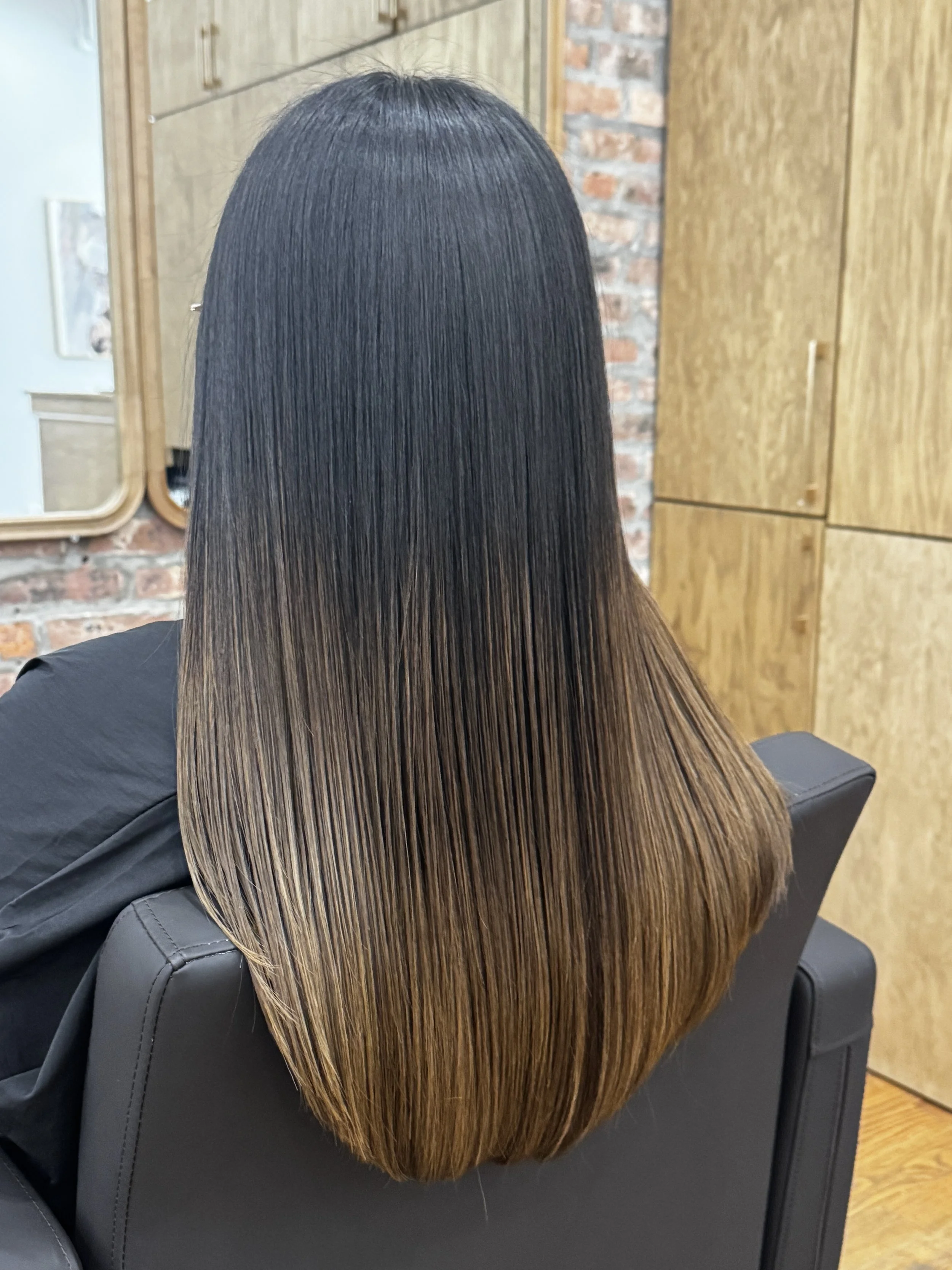 Long, smooth dark-to-light brown hair with a shiny finish after HITA hair treatment at U&K Salon in Brooklyn.