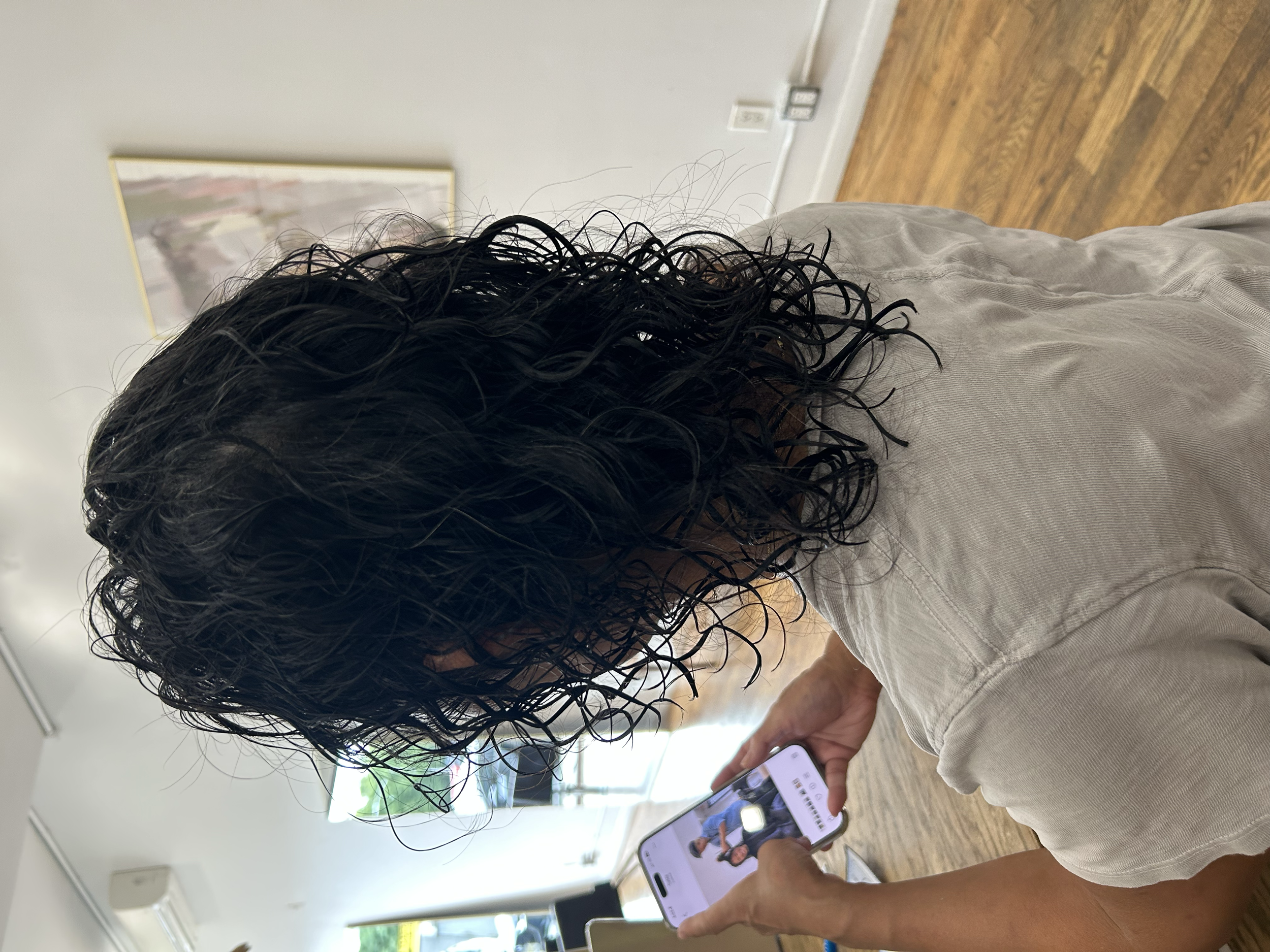 Medium-length dark wave perm with defined curls and layered volume, photographed from behind at U&K Salon.