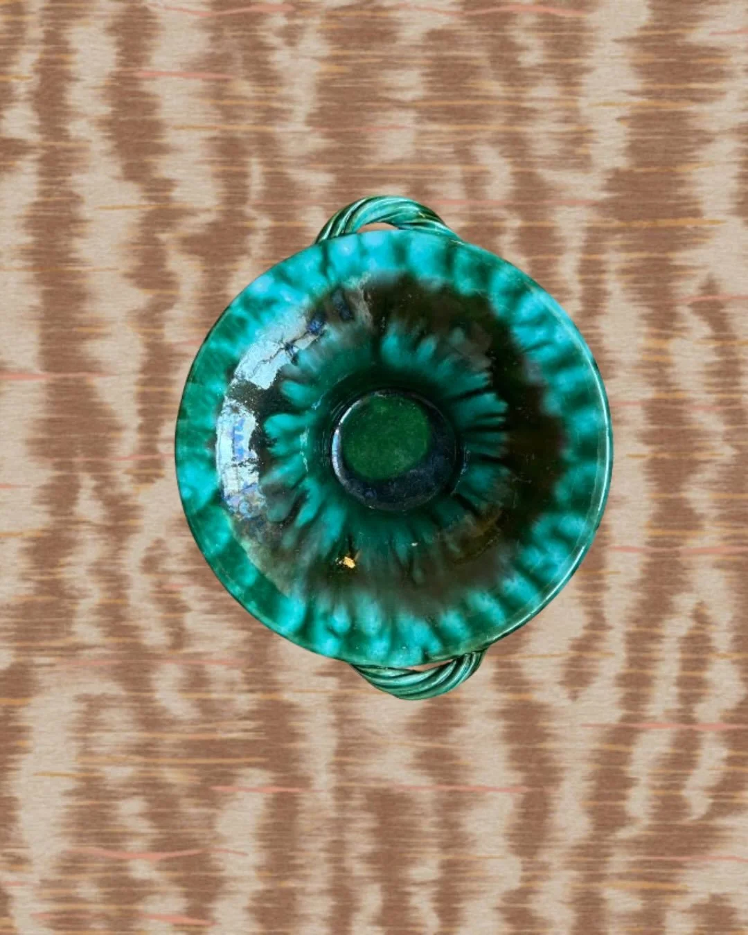 Plat en c&eacute;ramique &eacute;maill&eacute;e, fait main &agrave; Vallauris.
&Eacute;mail vert profond aux nuances turquoise marbr&eacute;es, anses torsad&eacute;es.
Quelques &eacute;clats anciens sur le pourtour inf&eacute;rieur, visibles sur les 