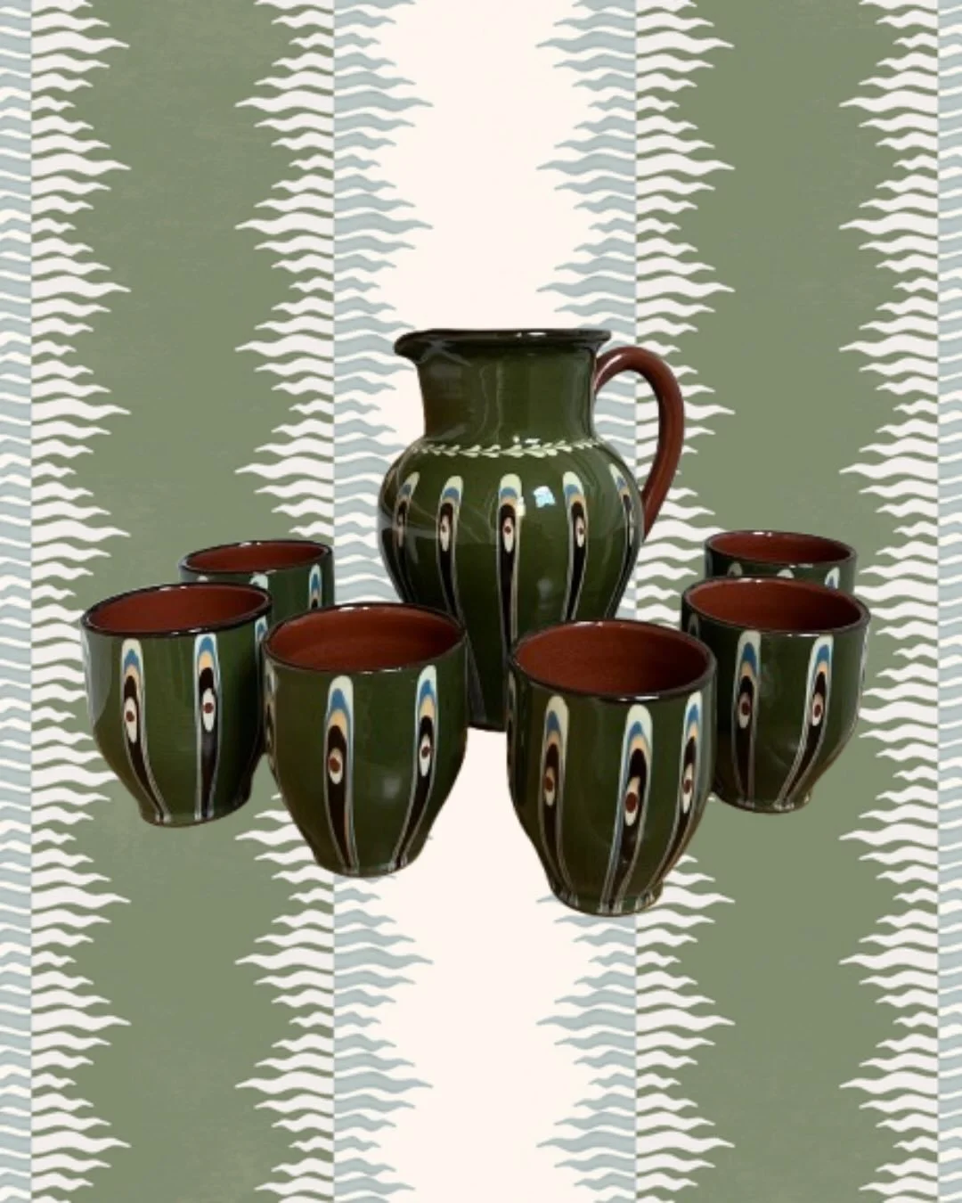 Service en c&eacute;ramique &eacute;maill&eacute;e, Europe de l&rsquo;est.
Pichet et gobelets assortis, d&eacute;cor&eacute;s de motifs g&eacute;om&eacute;triques et v&eacute;g&eacute;taux dans une palette de verts profonds, bruns et ivoire.

En tr&e